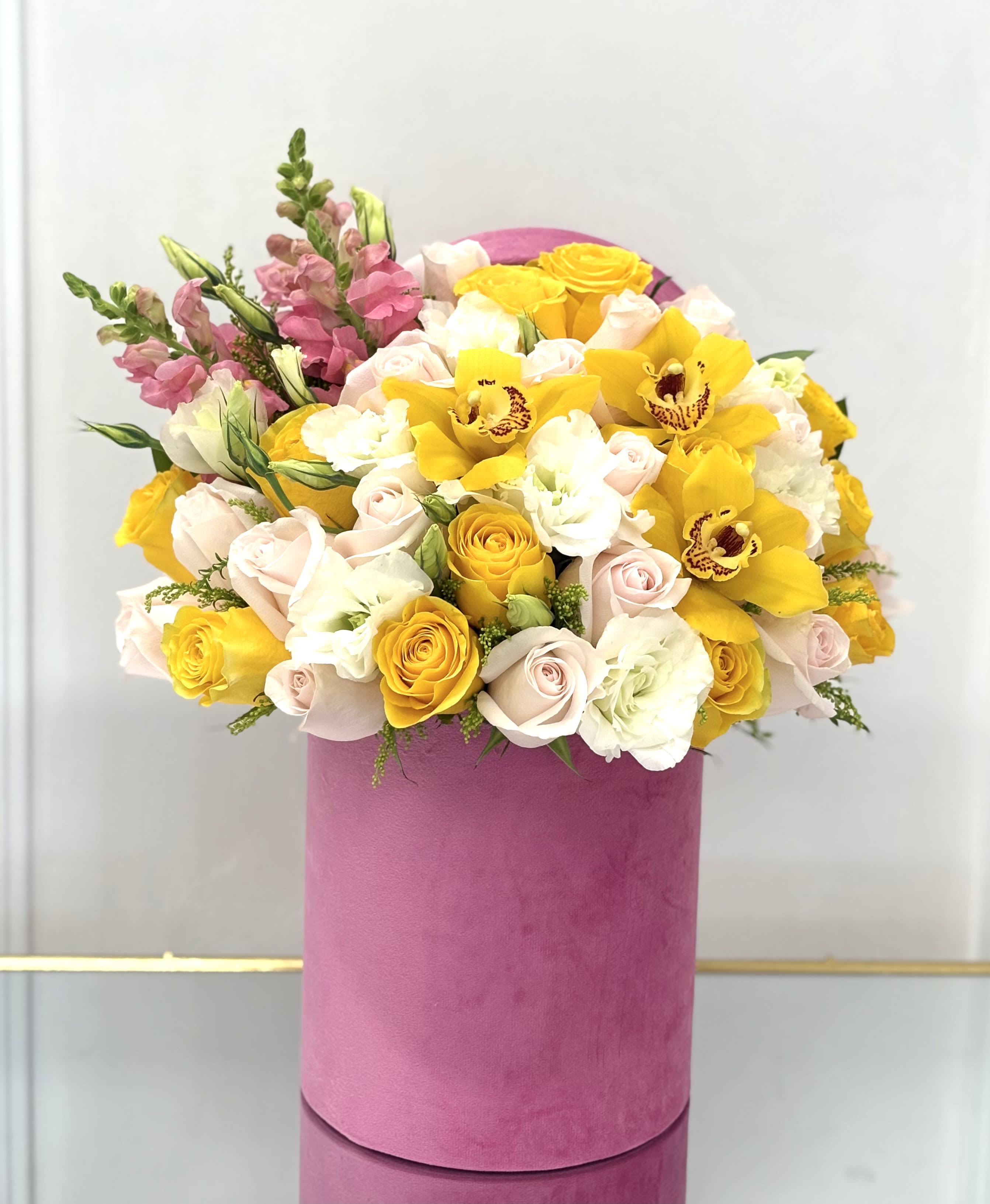 Golden Orchid By VLM Flowers - A radiant mix of yellow orchids, soft pink roses, and creamy whites—this cheerful arrangement lights up any room with sunshine and elegance.