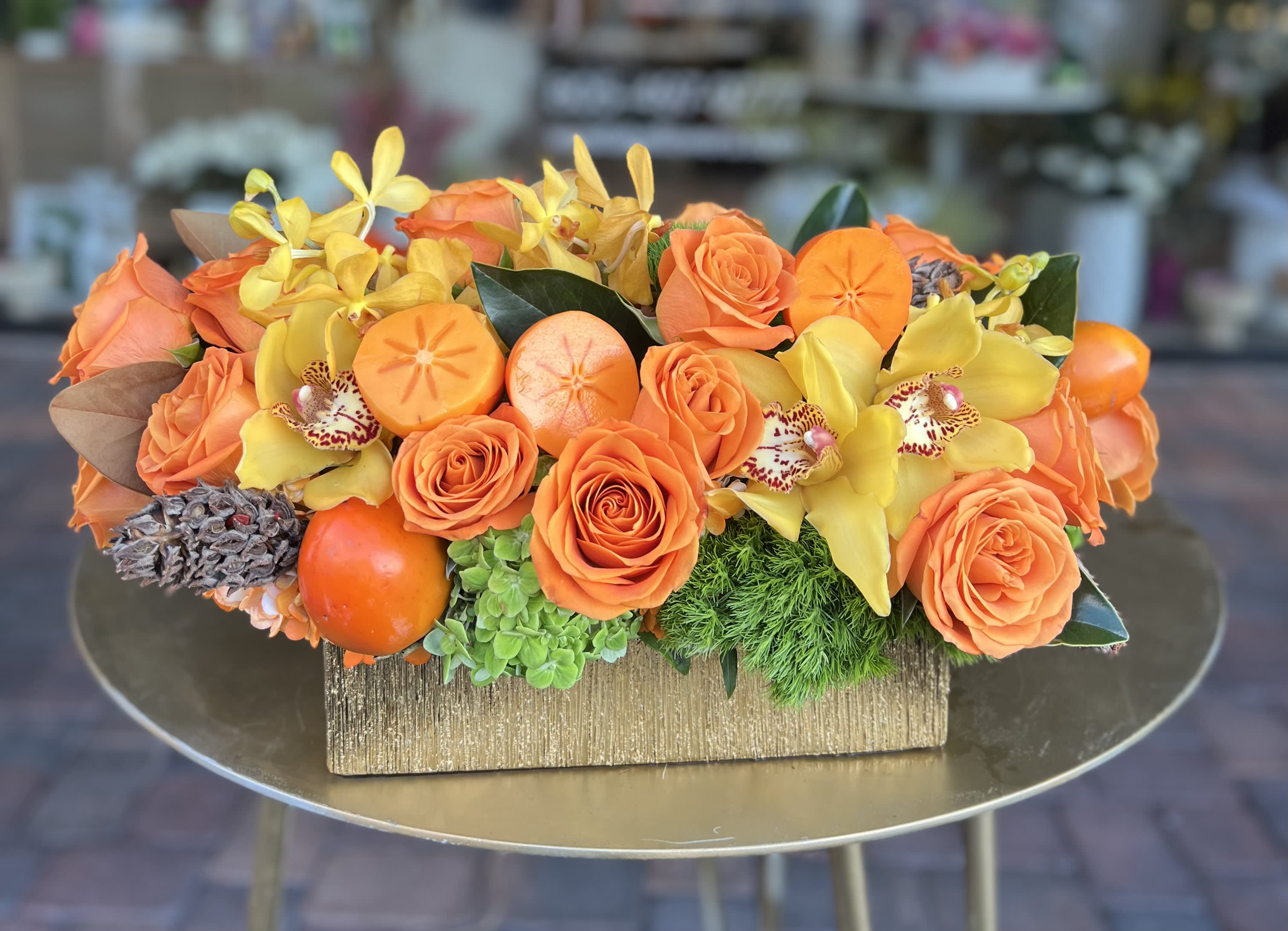 Harvest Bouquet Harvest Bouquet - Stunning centerpiece of orange and yellows including Hydrangeas, Roses, Orchids and more in gold vase