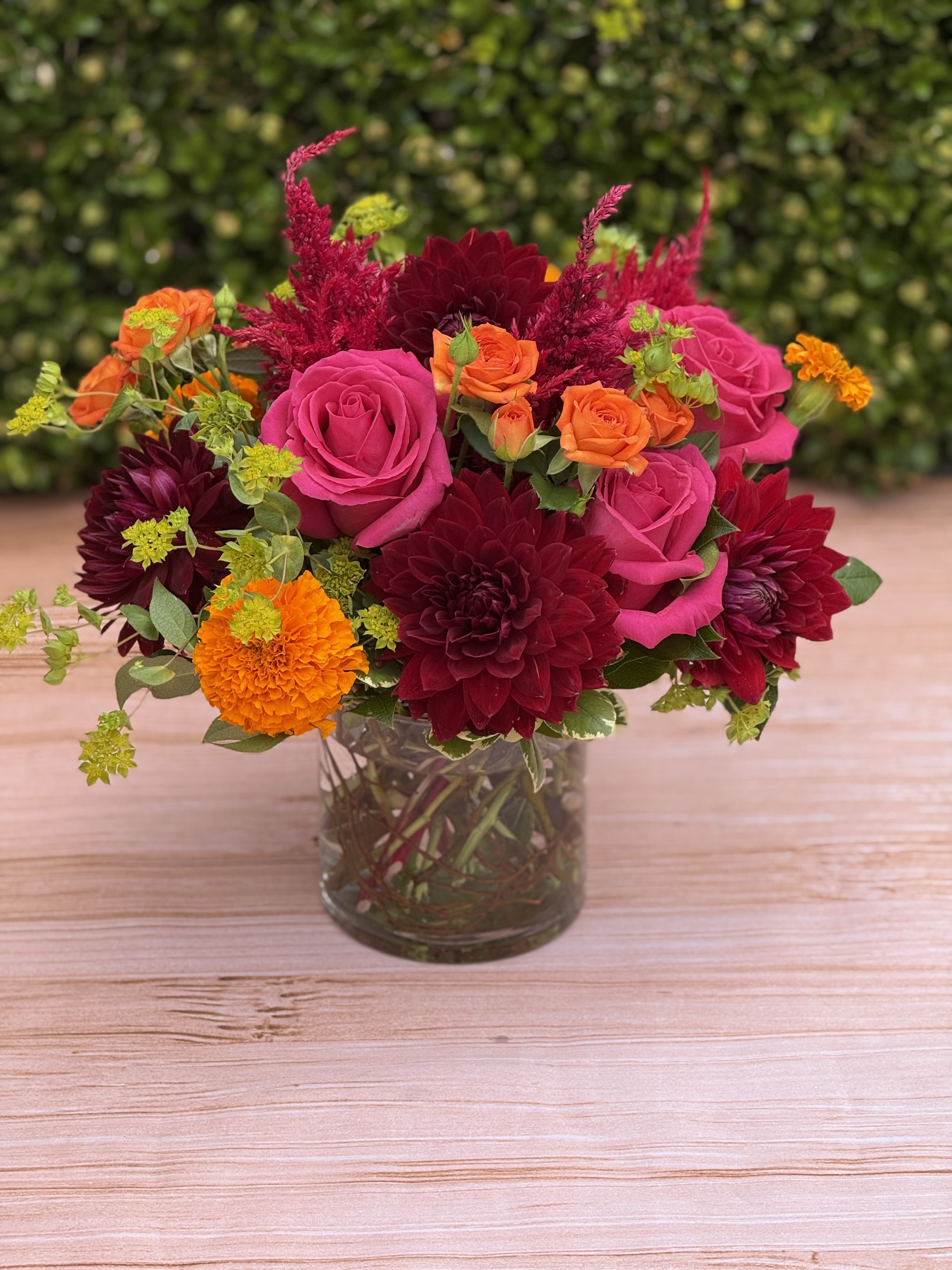 Autumn Glow - Enjoy the warm glow of brilliant autumn tones with this petite low and lush design featuring hot pink roses, orange marigolds, burgundy dahlia. 