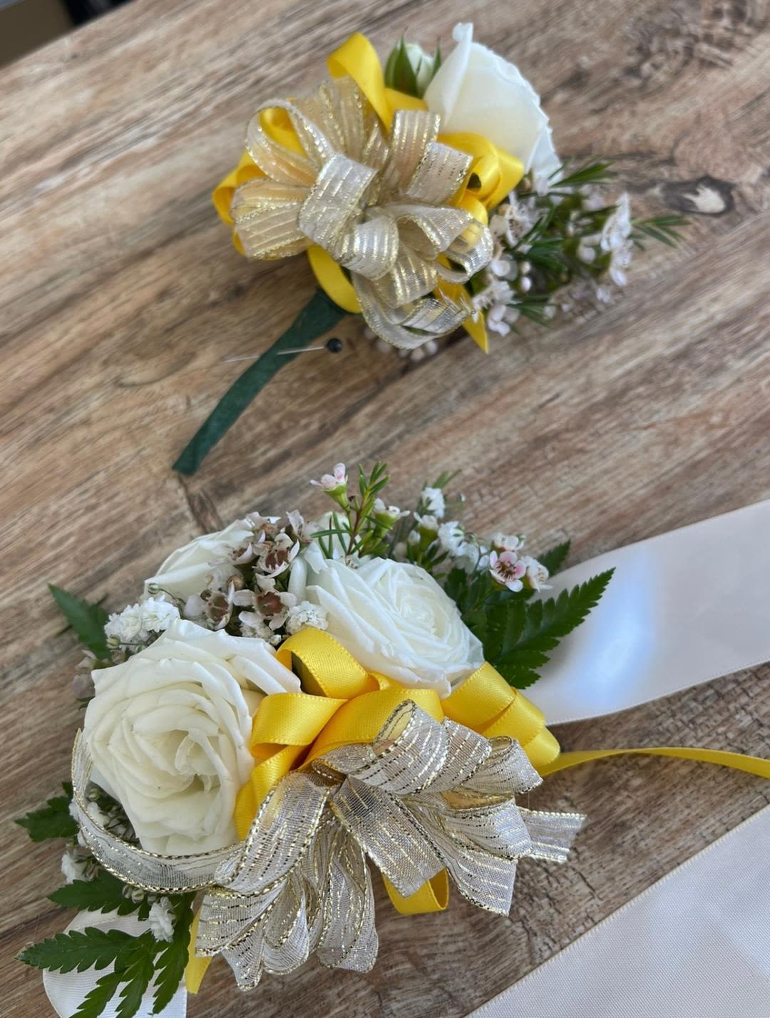  Lovely Yellow Corsage and Boutonniere Set  - Made from fresh flowers, a corsage looks like a petite flower arrangement (typically consisting of just one or several smaller blooms) and usually sits on the wrist like a bracelet, though it can also be pinned on a lapel. Corsages serve as a way to honor people who are very important to the couple getting married. Please contact our shop at (747) 249-4678 for any customization.      