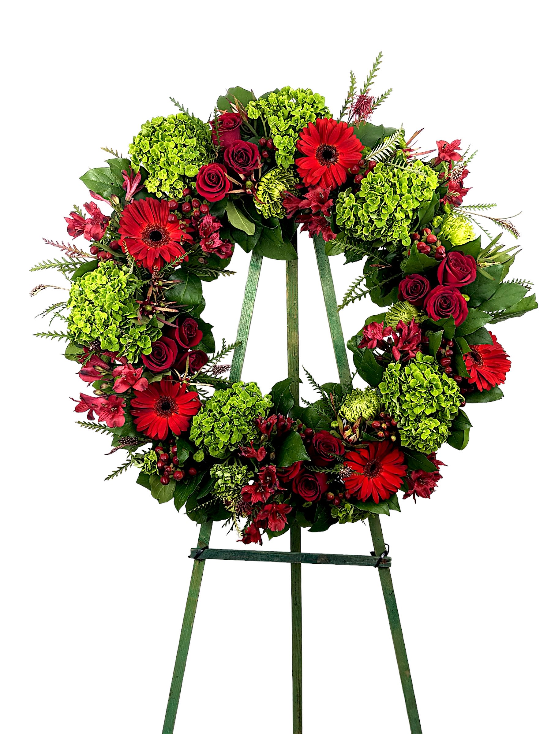 Sentimental Wreath Sentimental Wreath - Bright red Gerbera Daisies, Green Hydrangeas, and Deep red roses are arranged to create a lovely wreath for a funeral service. This type of design is usually approximately 5 - 6 ft tall and is meant for funeral services ONLY. This design includes a free banner (please include a banner sign in the Special Instruction Box or Message Box with the title “BANNER”). In the event a banner space is left blank for any reason, ONLY a card message will be included. Banners are printed in a black 2.5-inch wide ribbon with silver ink. Currently, we don't offer any other colors. If the service is the same day as the order was placed we cannot guarantee delivery by a certain time. And flowers will be delivered during normal business hours. To ensure the delivered flowers match the displayed photo as close as possible we recommend ordering 3-5 days in advance. For the same or next day deliveries, we reserve a right to substitute flowers with the same or greater value.