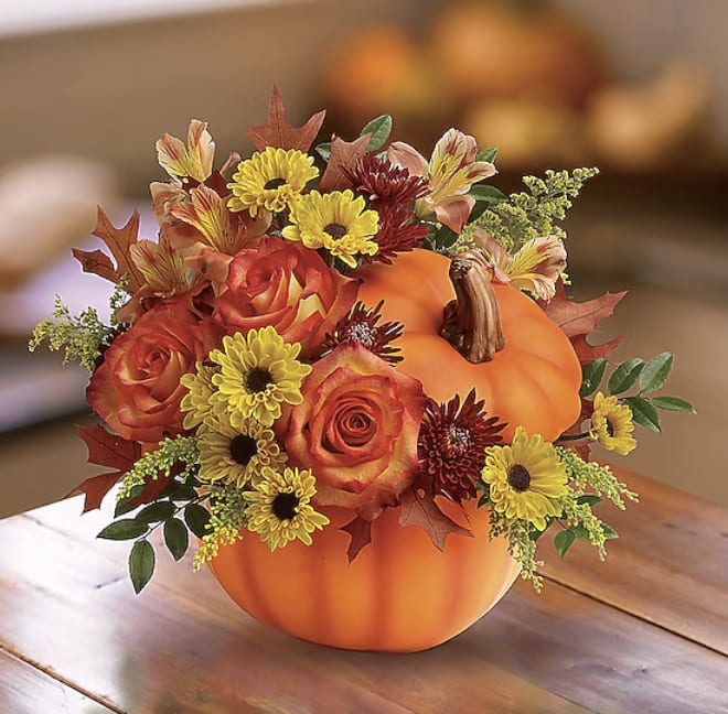 Ceramic Pumpkin Bouquet - Ceramic Halloween Pumpkin with gold stem. Don't go to the pumpkin patch this year. Instead send this gorgeous arrangement of seasonal stems, artfully arranged in a pumpkin vase to deliver some happiness. The Deluxe Bouquet is approximately 10&quot;H x 11&quot;W. Designed by your Posie florist. Replace the water daily. Not pet friendly. Flowers may include mini sunflowers, orange roses, asters, fall leaves and wheat stems. If possible, note in instructions pumpkin with face or no face. We have both. 