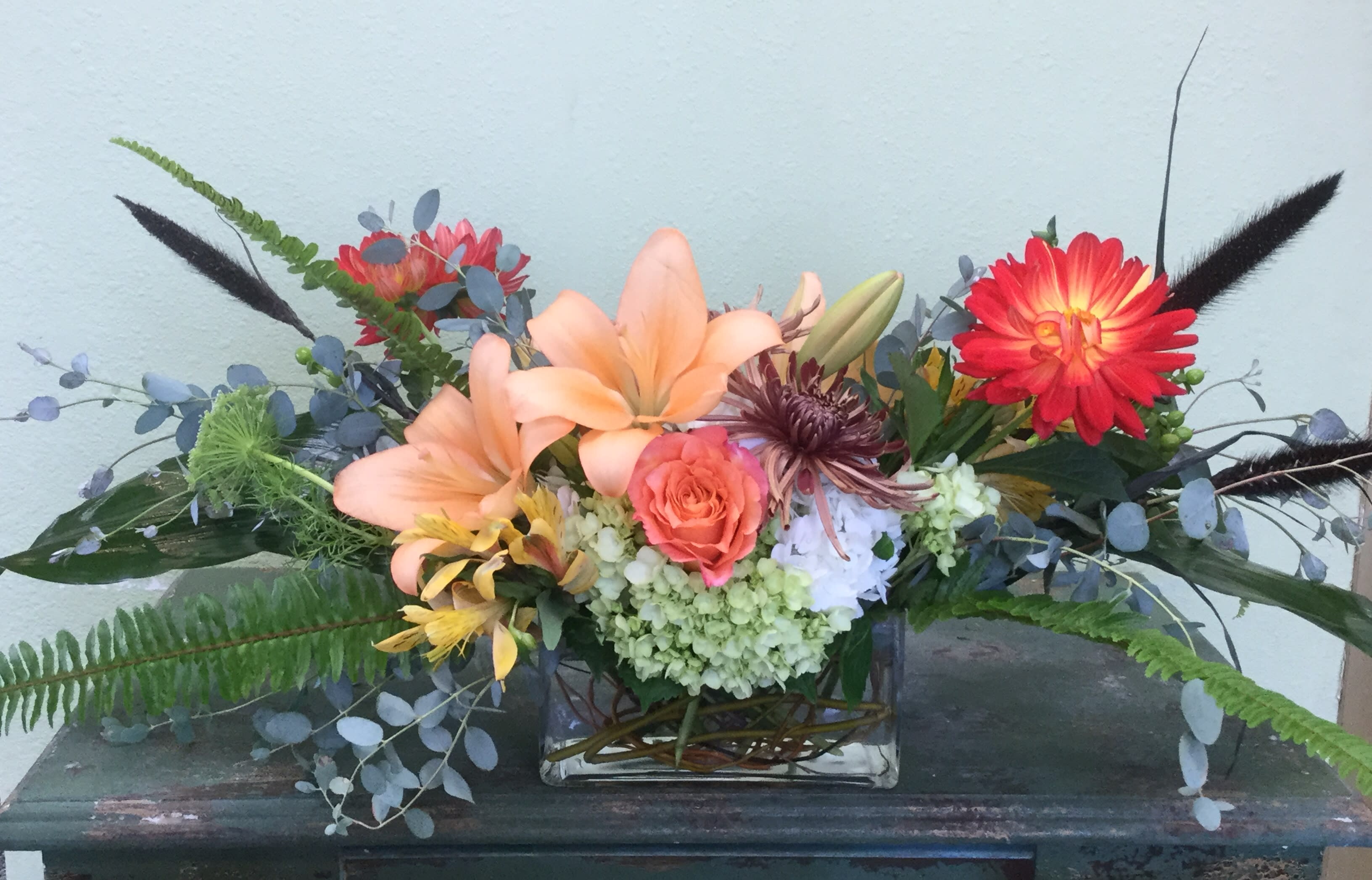 Modern Gathering - A contemporary design just perfect for your dining table or mantle!  This seasonal,  modern arrangement features premium blooms like hydrangea, roses, and lilies mixed with gorgeous, airy eucalyptus greens. Flowers may vary, please call if this is a concern. 