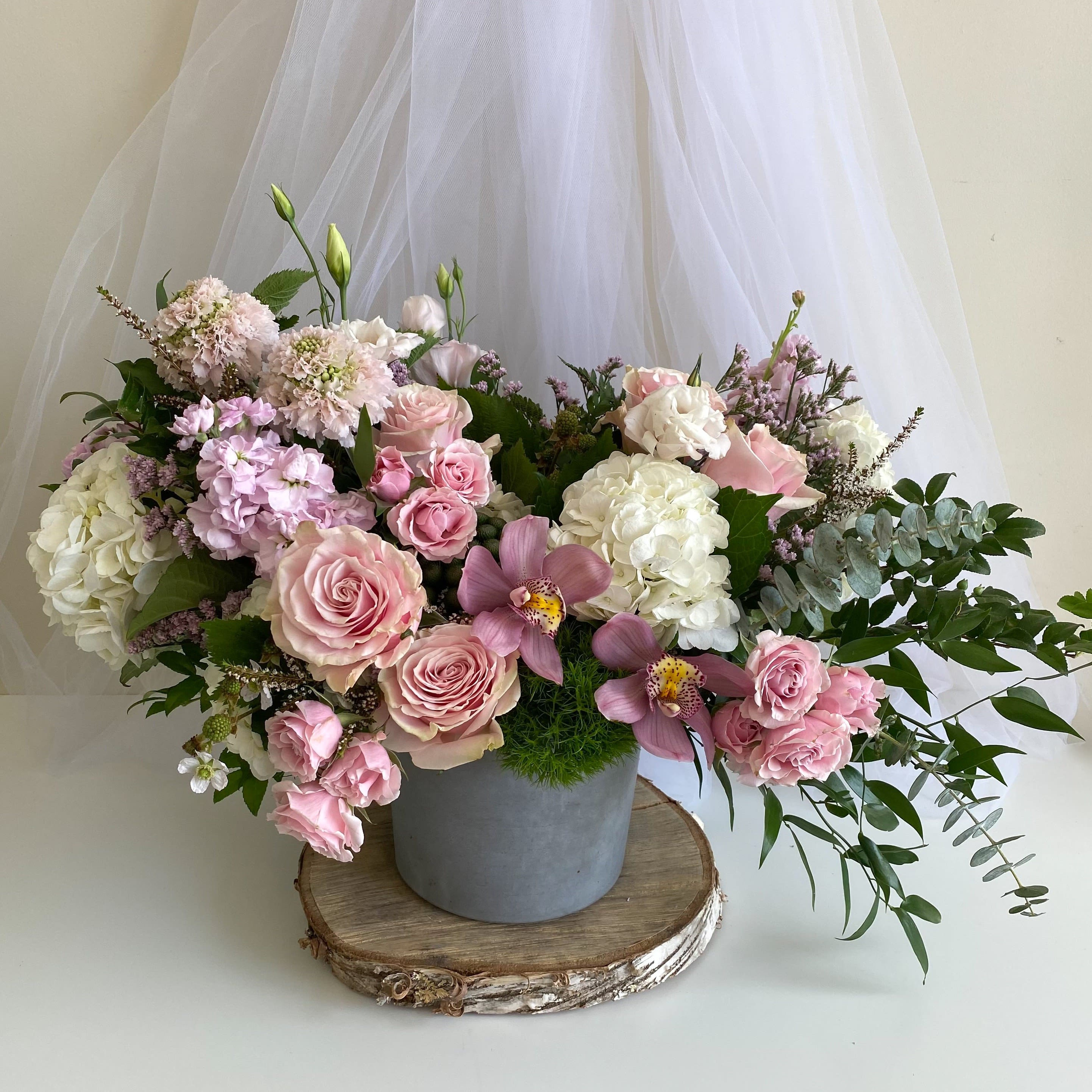 Stardust  - Theme Colors: Shades of pinks with purples  Featured Blooms: Roses, Orchids, Hydrangea, Spray Roses, Seasonal Blooms  HK Flowers have a uniqueness of florals and seasonal blooms, certain flowers or colors may not be available as each season affects the availability, color, size, and shape of each floral bloom. Some flowers may be substituted accordingly.  Photos are used as a reference for the color palette and is NOT indicated of the final product. We ask for your trust in us that we will pick out the best seasonal available blooms, while still capturing the arrangements theme and colors mentioned above.