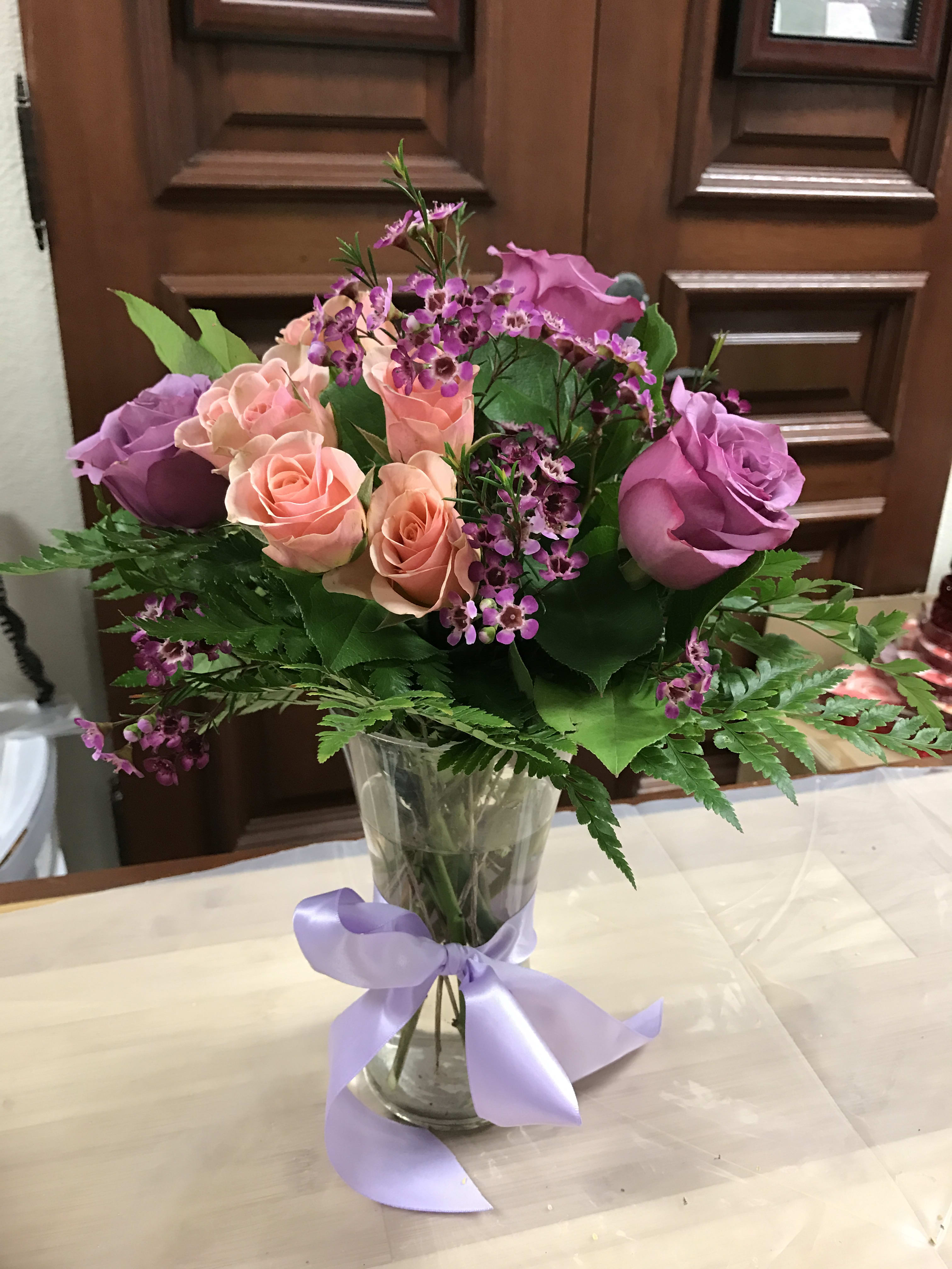 Sweet Roses - Recipe: Lavender Roses, Pink Spray Roses, Dianthus and Greens in medium, clear vase with Lavender Ribbon. Seasonal: All year round Design View: All Facing View Photo shown: Standard 