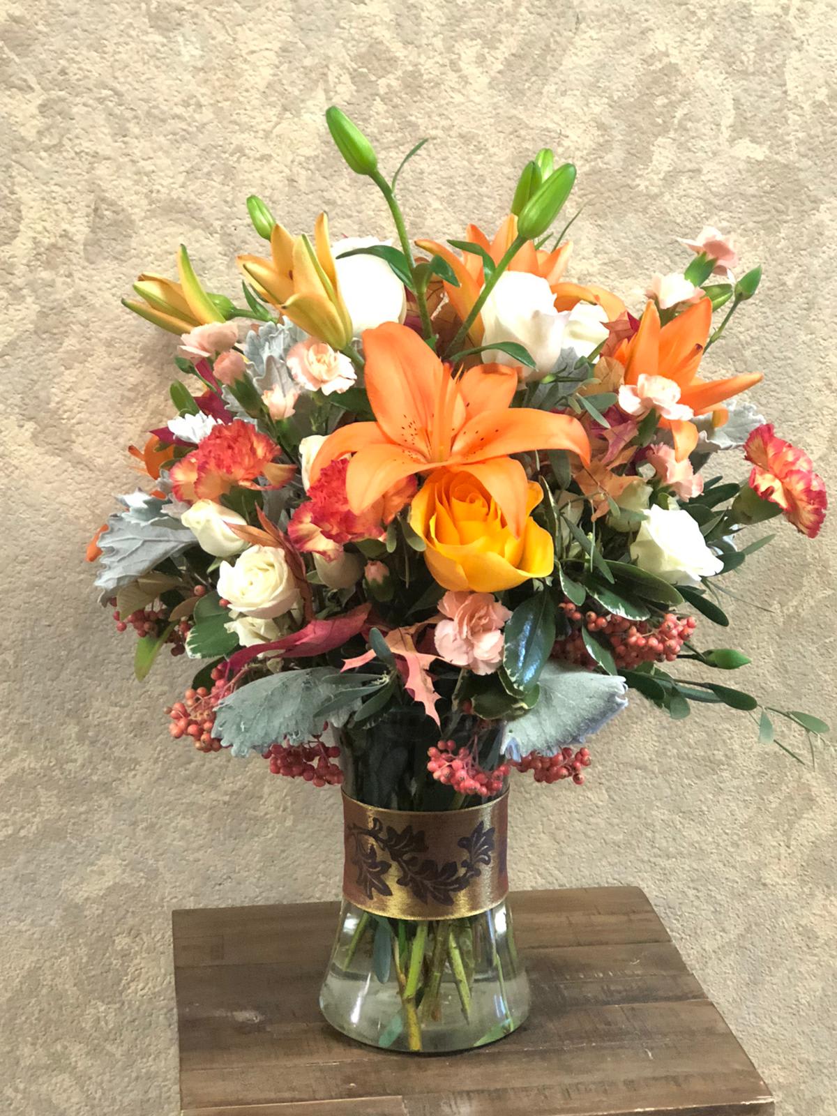 Autumn You Falling For Me Autumn You Falling For Me - Type of Flowers: Purple Stock, Orange Roses, White Spray Roses, Orange Asiatic Lilies, Red Carnations, Berries and Dusty Miller with silk fall leaves in a tall glass vase with ribbon. Seasonal: Autumn Orientation: All-sided Facing View Photo shown: Standard