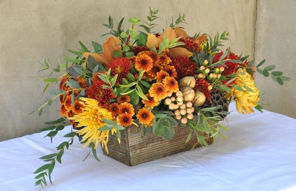 Fall Fantasy Box Arrangement - Burnt oranges pair well with soft peaches and greens in this design featuring three types of mums, Hypericum berries and Lillies. 
