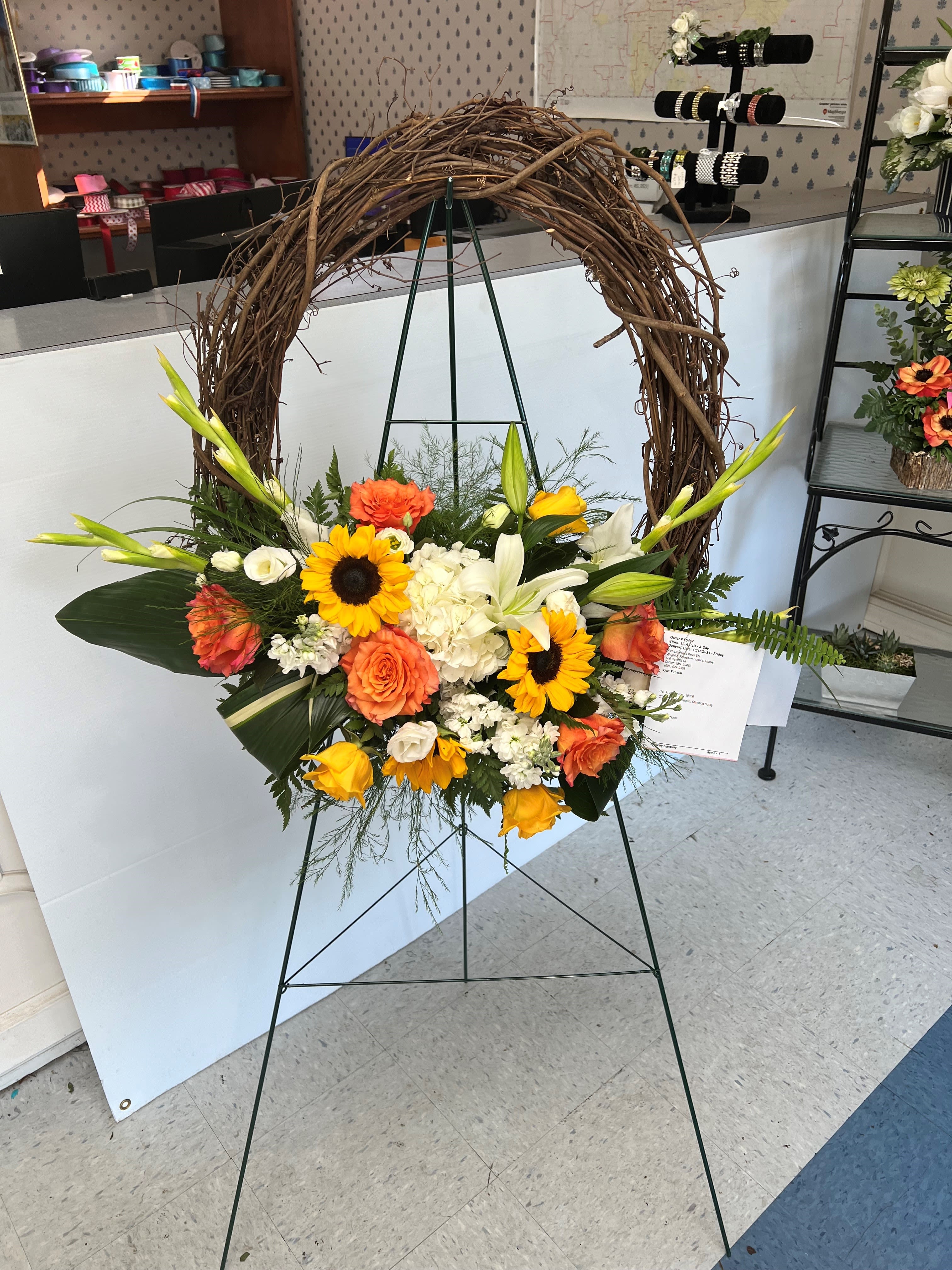 Grape Vine Wreath Standing Spray - Grape vine wreath is all natural live flowers attached as seen.  Please make a note of what colors you would like or call us to order.  Please note: Flower varieties and colors may be substituted based on seasonal and daily availability. We always ensure your arrangement is of equal or greater value and just as beautiful.