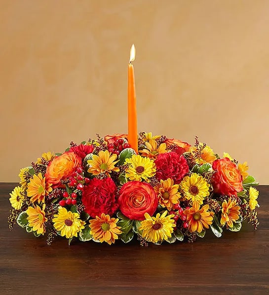 Autumn Wishes Centerpiece -  Send your warmest wishes to the people you love with our colorful autumn centerpiece. This traditional table arrangement is designed with radiant blooms and finished off with an orange taper candle to cast a cozy glow over seasonal gatherings