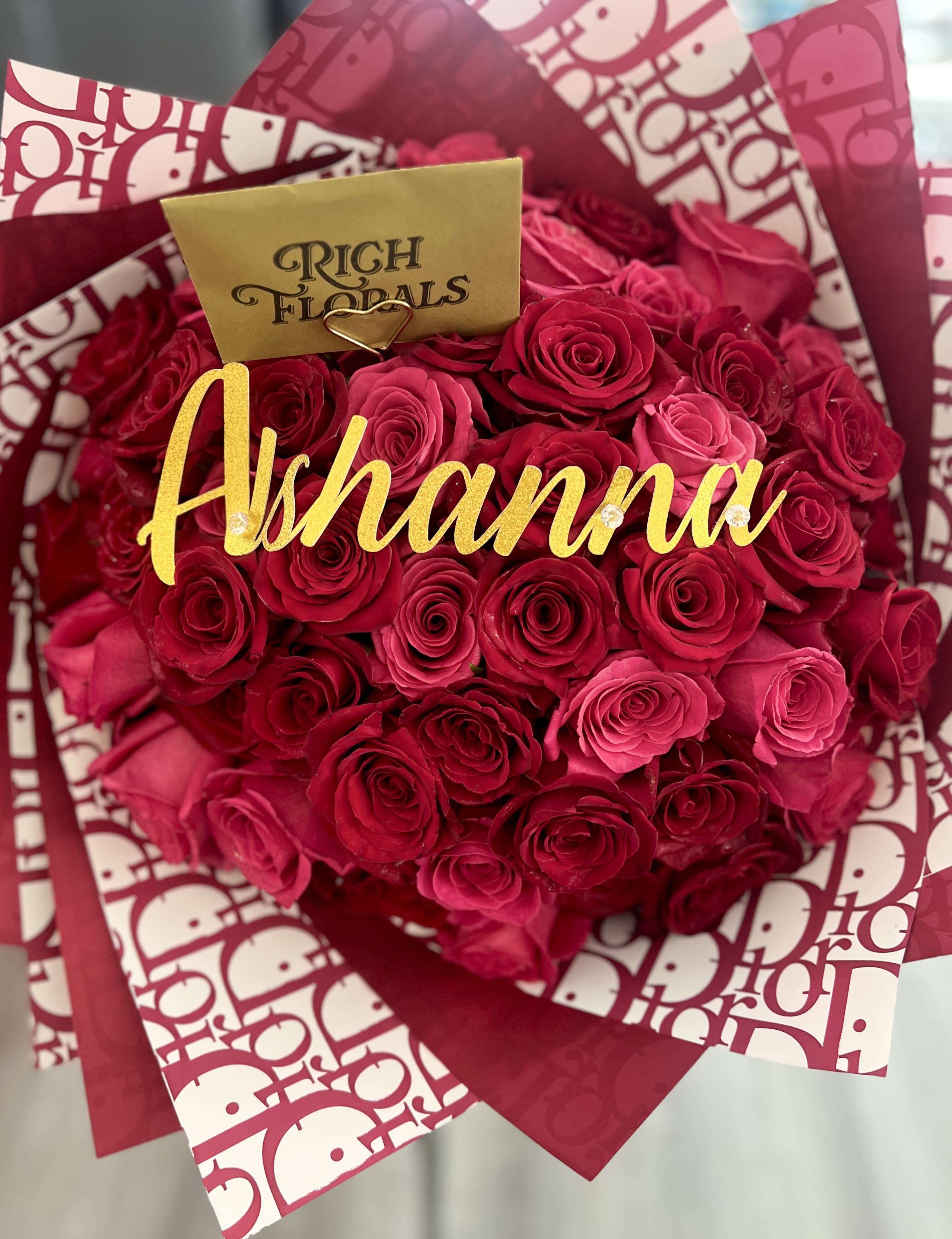 Rosy Dior Bouquet - Featuring 50 roses (25 red and 25 hot pink roses) wrapped in luxurious Dior paper and tied with a signature Dior ribbon. Includes a custom name topper—don’t forget to leave the name in your checkout notes!