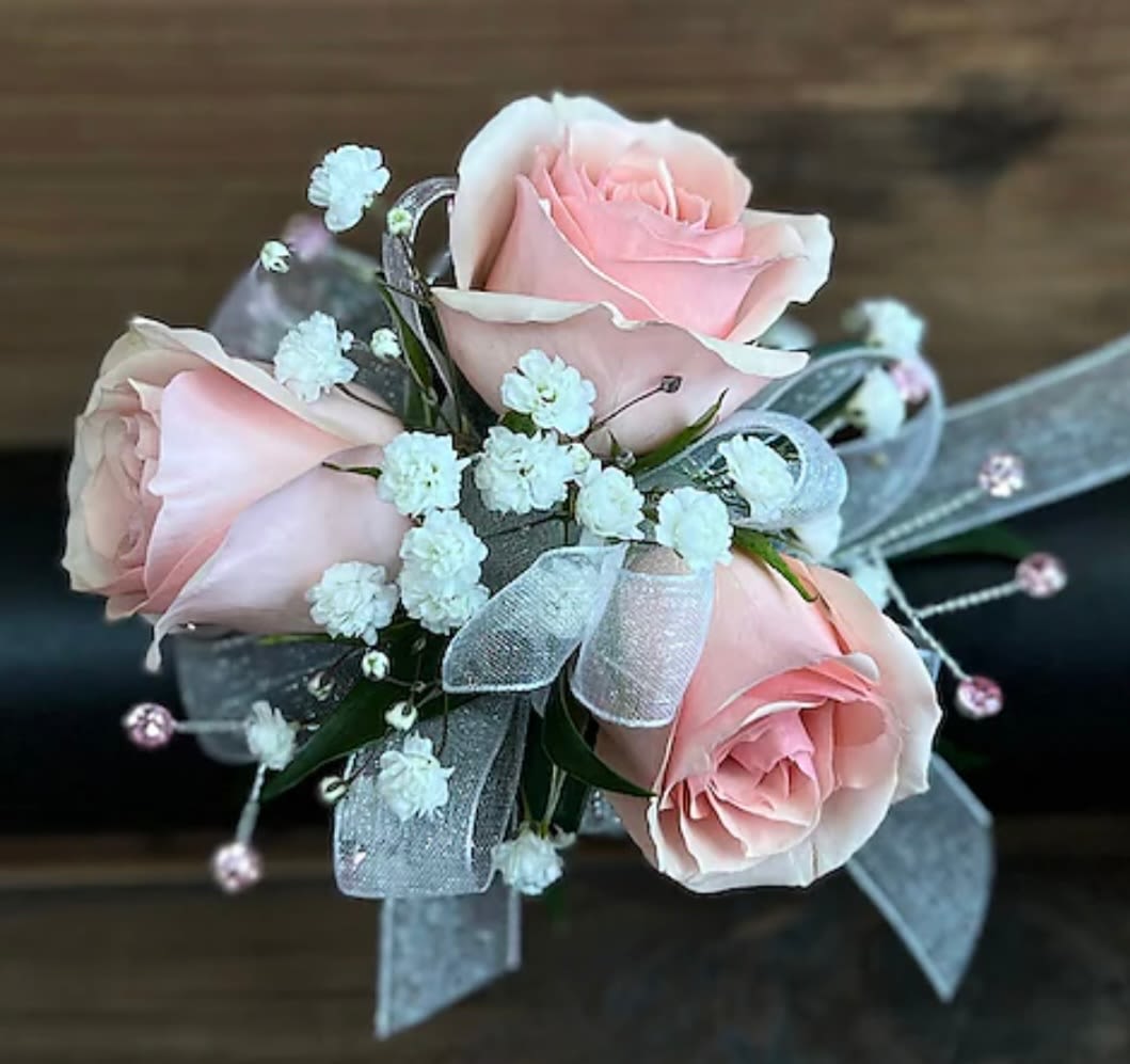 Pastel pink corsage - Pastel pink roses on a wristlet with babys breath. Accented with gems