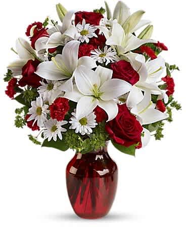 Romantic Radiance Bouquet - Make their heart skip a beat with our Romantic Radiance Bouquet. This breathtaking arrangement features velvety red roses, elegant white lilies, cheerful daisies, and lush greenery — all hand-arranged in a Clear glass vase.  Perfect for anniversaries, Valentine’s Day, birthdays, or simply saying ‘I love you,’ this bouquet combines timeless romance with striking elegance. The rich red and crisp white blooms create a dramatic and unforgettable floral gift.  We proudly offer same-day flower delivery in The Colony, Frisco, Little Elm, Plano, Carrollton, Lewisville, and across the Dallas–Fort Worth metroplex. Surprise someone special today with a bouquet that speaks straight from the heart.