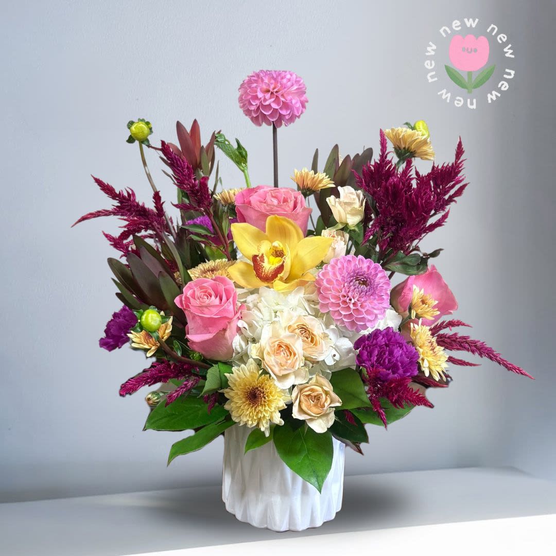 Sunset and Sangria - Celebrate the final days of summer with our berry-and-blush beauty — inspired by golden sunsets and late-summer soirées. Featuring seasonal dahlias (snag them while they last!), soft pink roses, sunny yellow blooms, and rich burgundy amaranthus for that perfect end-of-summer warmth.  Season: Seasonal Dahlias Orientation: Front Facing View Photo shown: Standard