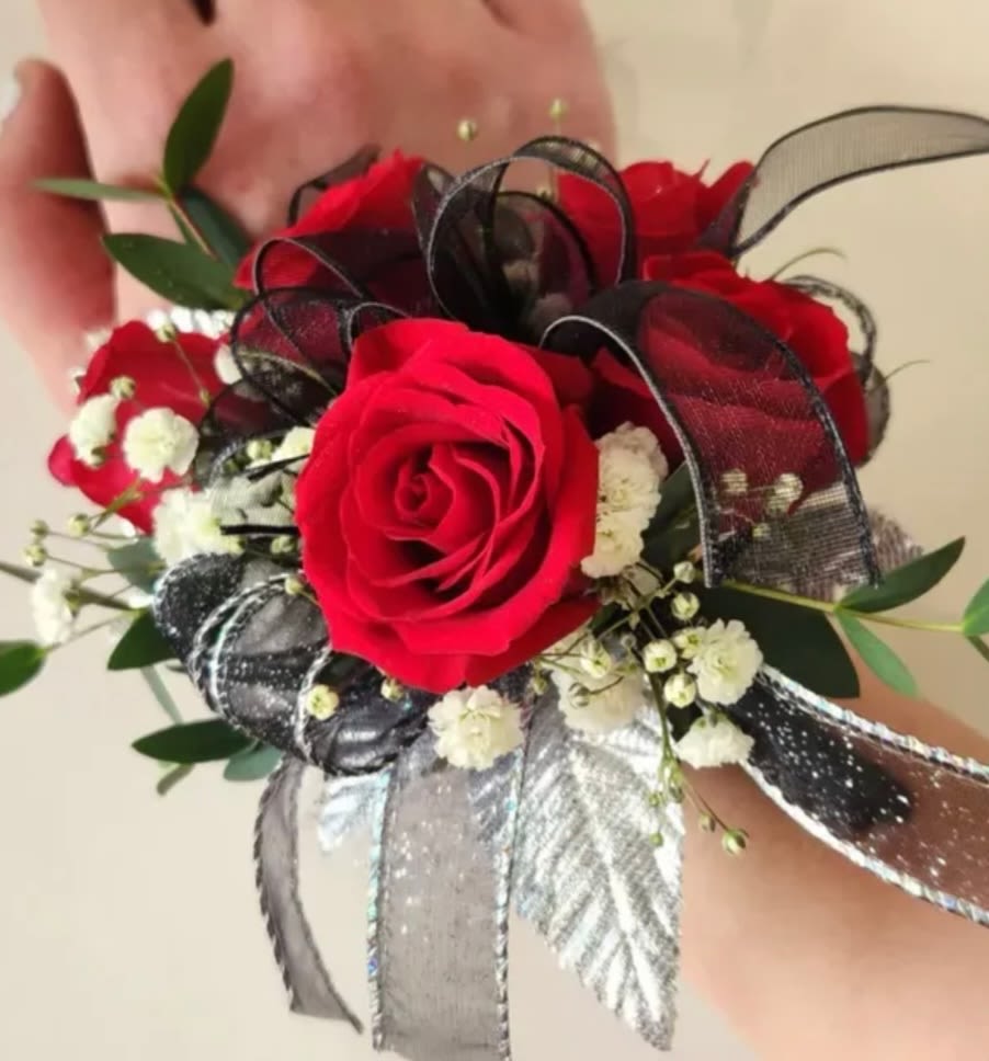 Red roses corsage - This wrist corsage is made up of red spray roses, filler and ribbon of choice.