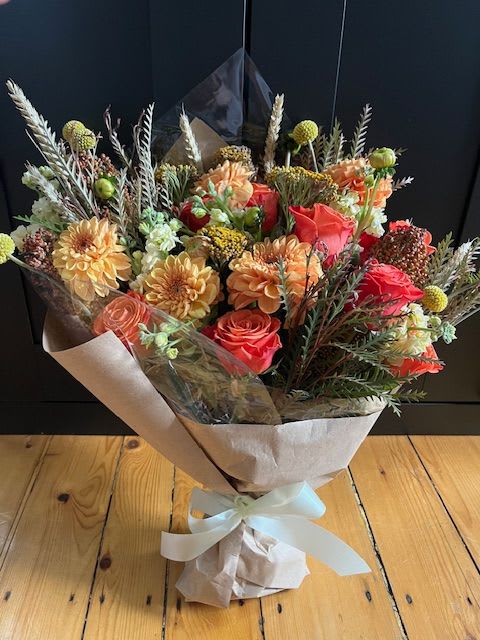Autumn Harvest Bouquet - Celebrate the warmth of the season with this bouquet that captures cozy charm in every petal!   This thoughtfully curated bouquet features a stunning mix of gentle oranges and yellows of dahlia, roses, stock and craspedia blended with seasonal foliage and autumn accents.  A perfect bouquet to say Thank you, celebrate a fall birthday or bring a little bit of seasonal beauty into the home.  