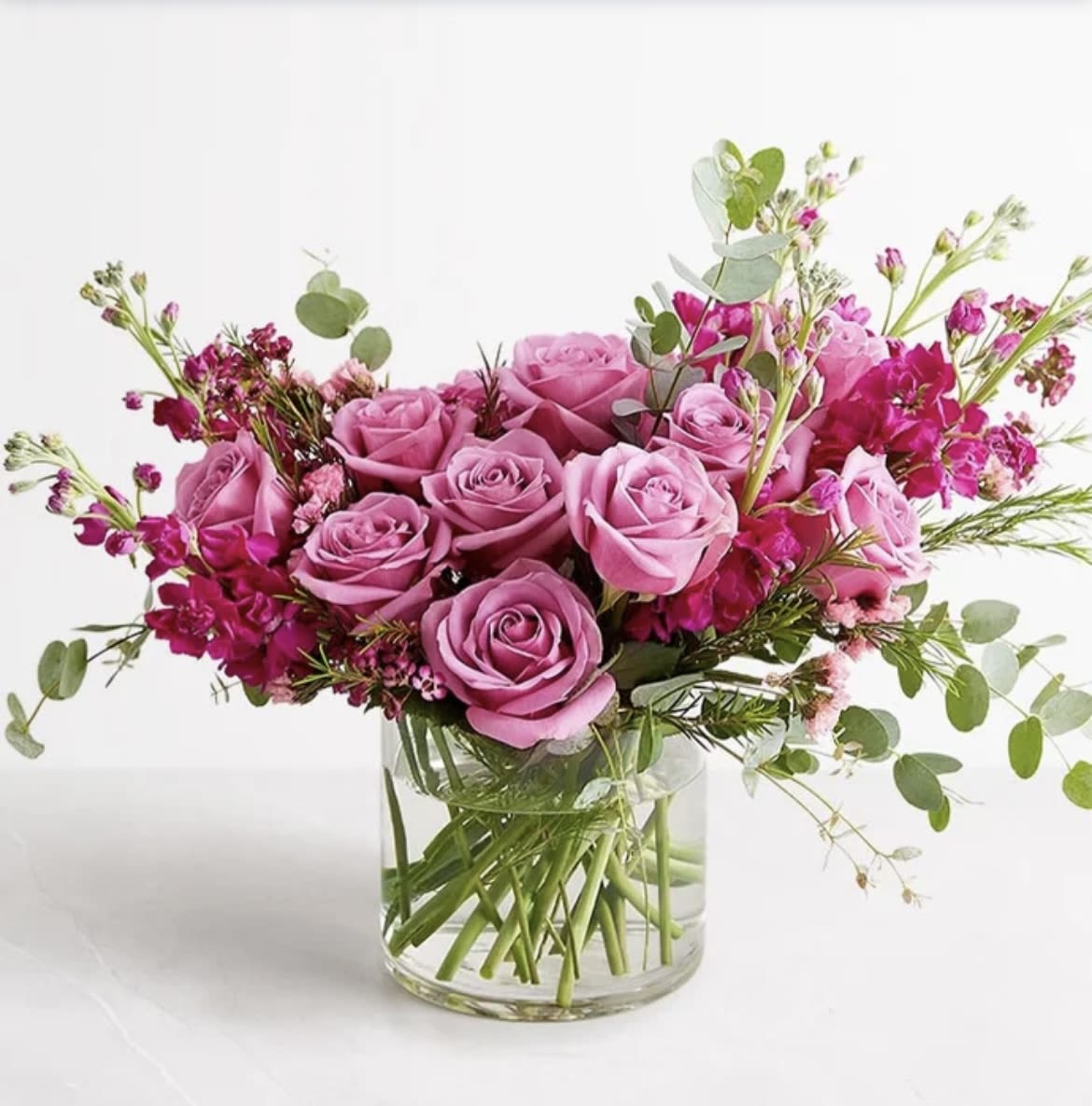 lavender garden  - One dozen lavender roses surrounded by stock , eucalyptus and lily grass .