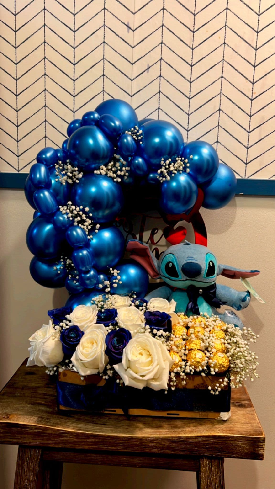 mini deco sitch - elaborado con una decoracion en globos azules, con 7 rosas blancas y 5 rosas azules con 12 chocolates ferrero