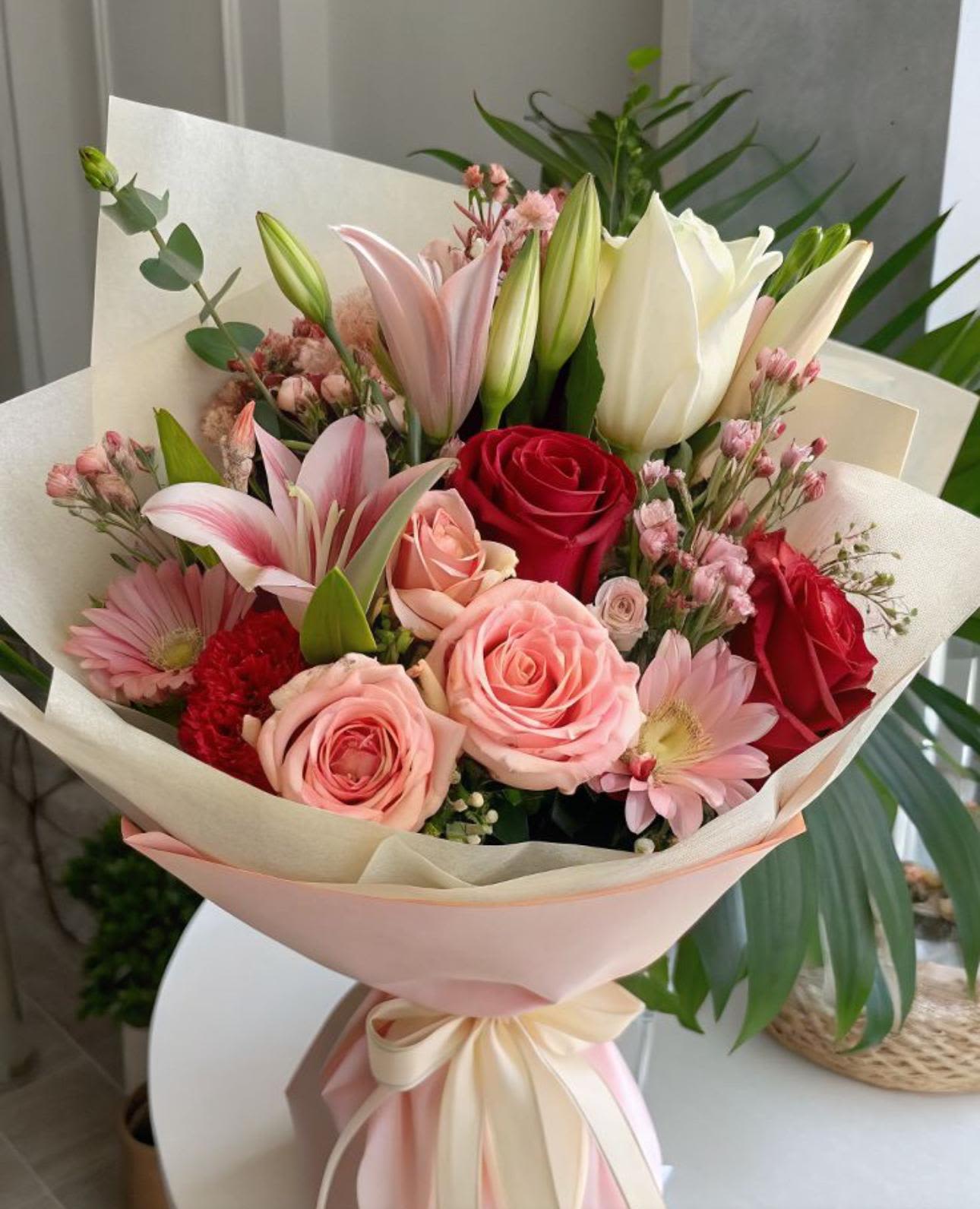 Passion Bloom Wrapped Passion Bloom Wrapped - Passion Bloom is a vibrant symphony of elegance and romance. With its striking red and blush roses, delicate pink lilies, and gerberas. This Bouquet captures the essence the essence of love, admiration, and heartfelt emotion. Wrapped in beautiful paper and tied with with flowing ribbon, it's perfect for someone who makes your heart bloom.