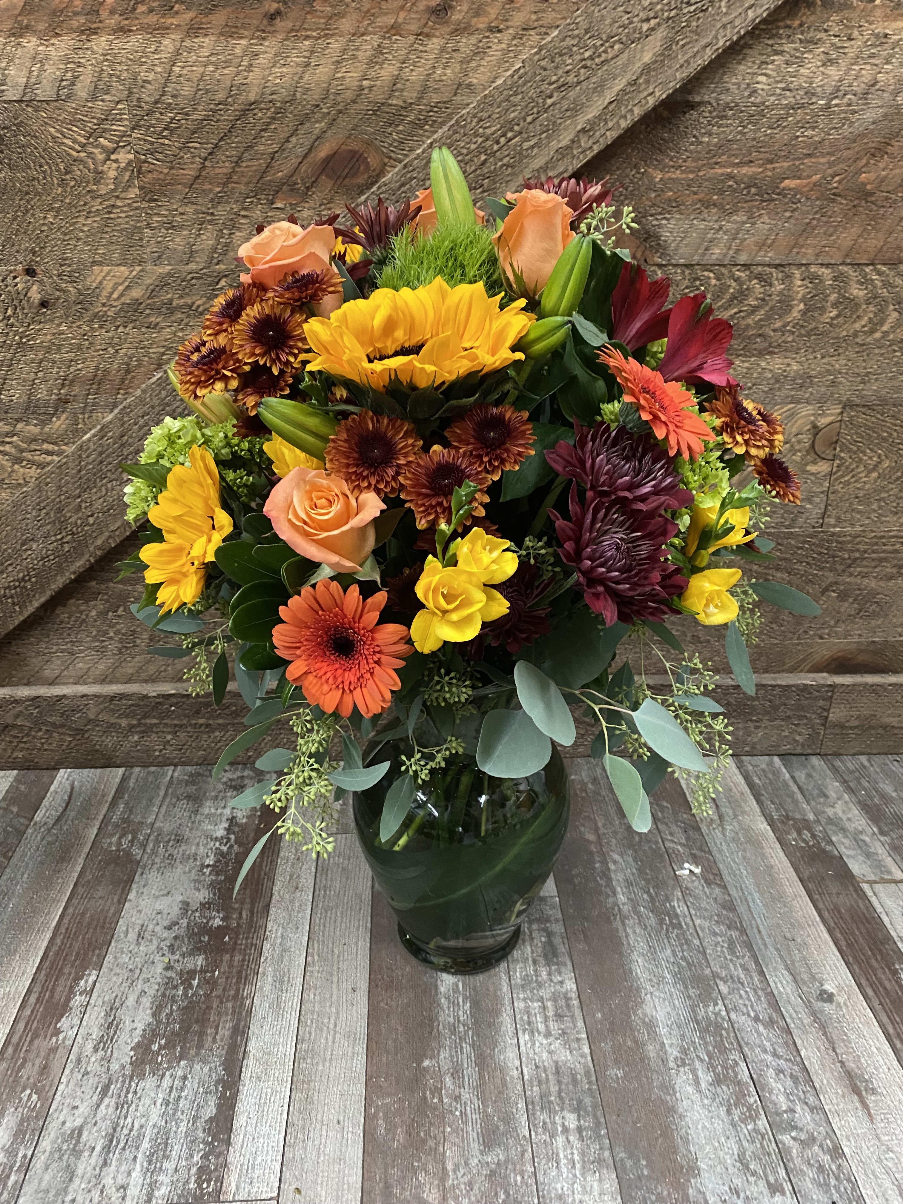 Autumn Happiness  - A stunning tall arrangement. Roses, gerbera daisies, mums, sunflowers, hydrangeas, protea, eucalyptus and more.  