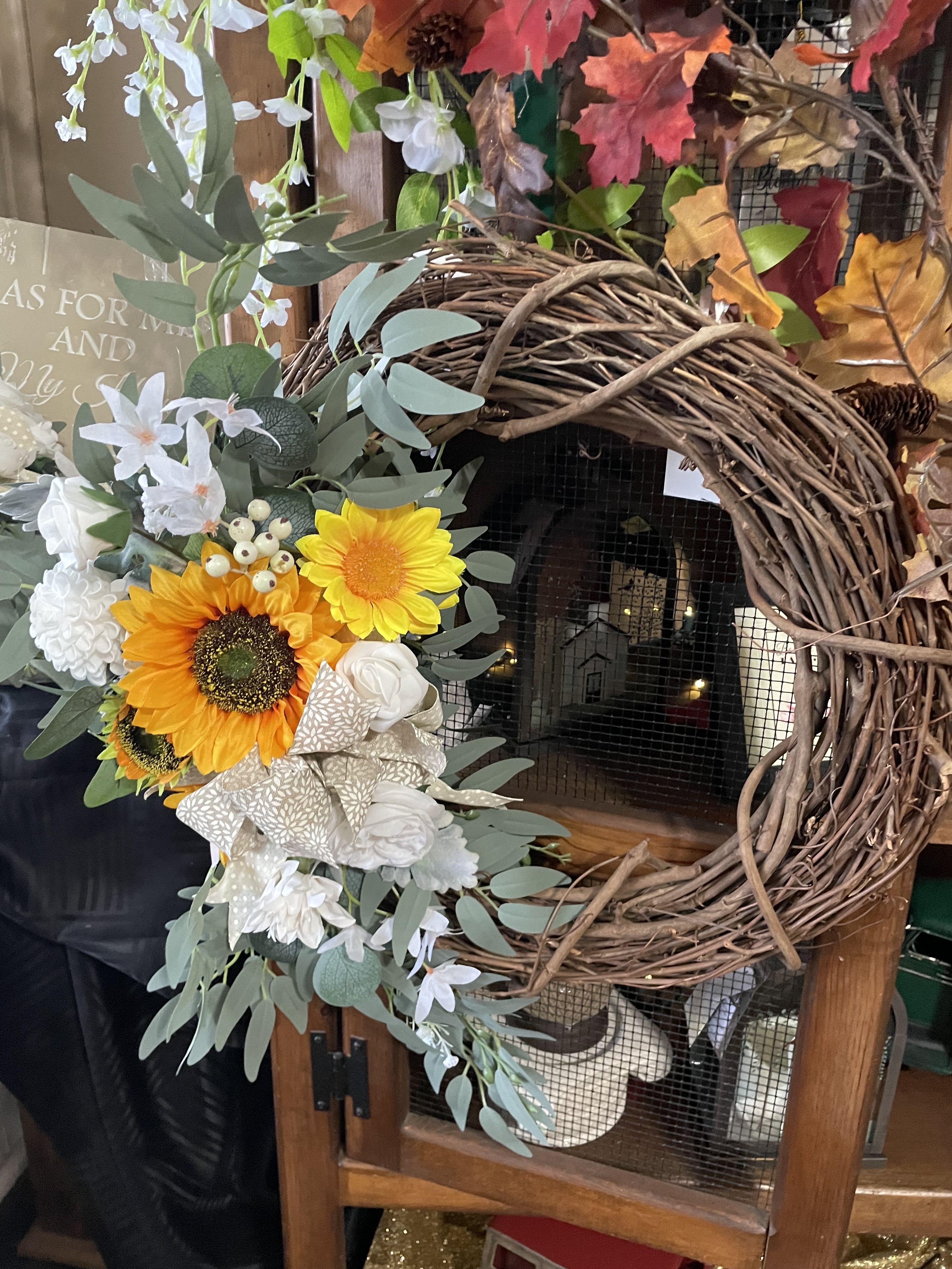 Sunflower Silk Grapevine Wreath Sunflower Silk Grapevine Wreath - Bright and cheery are Sunflowers. Surrounded with ribbons . This is a medium sized grapevine wreath. Put on an easel for funeral services.
