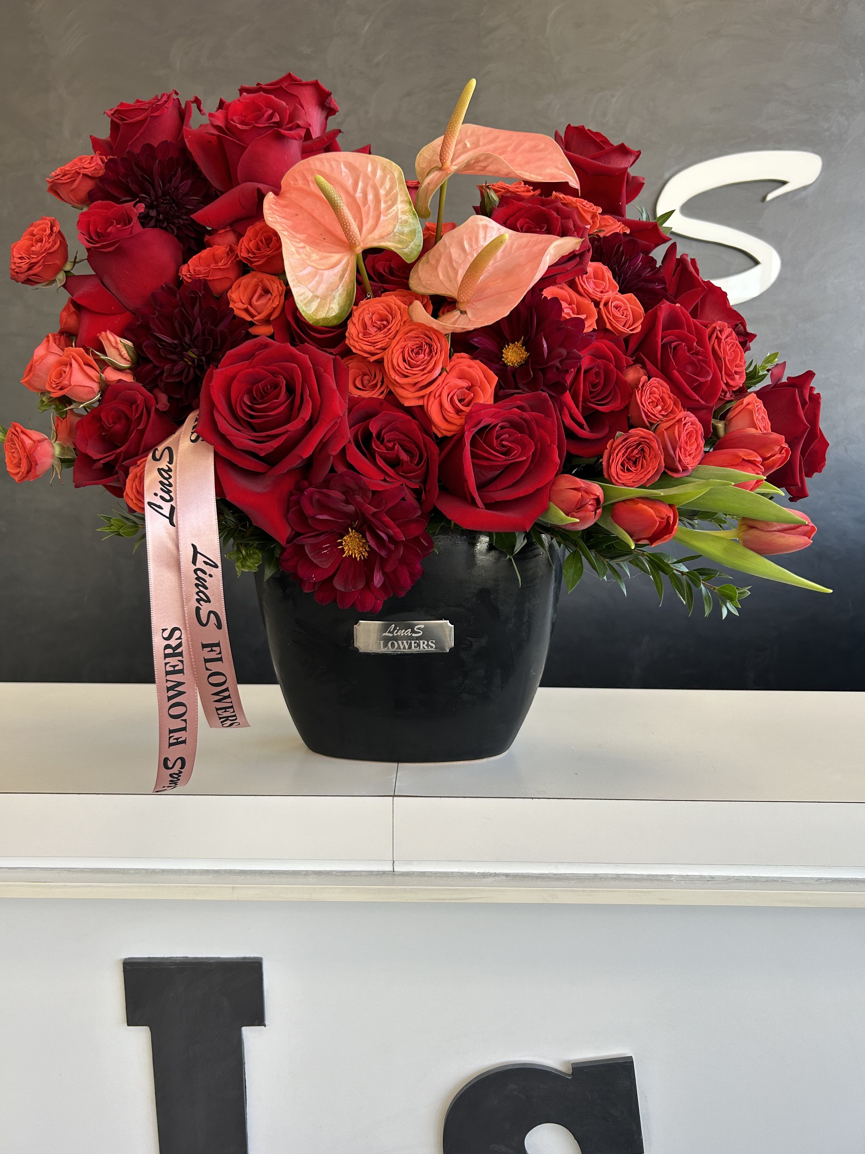 Miru Miru - A vibrant bouquet featuring a beautiful mix of pink, purple, and red tulips paired with elegant roses. The bold tulips add a lively touch, while the roses bring a sense of romance and sophistication, creating a striking and colorful arrangement for any occasion.