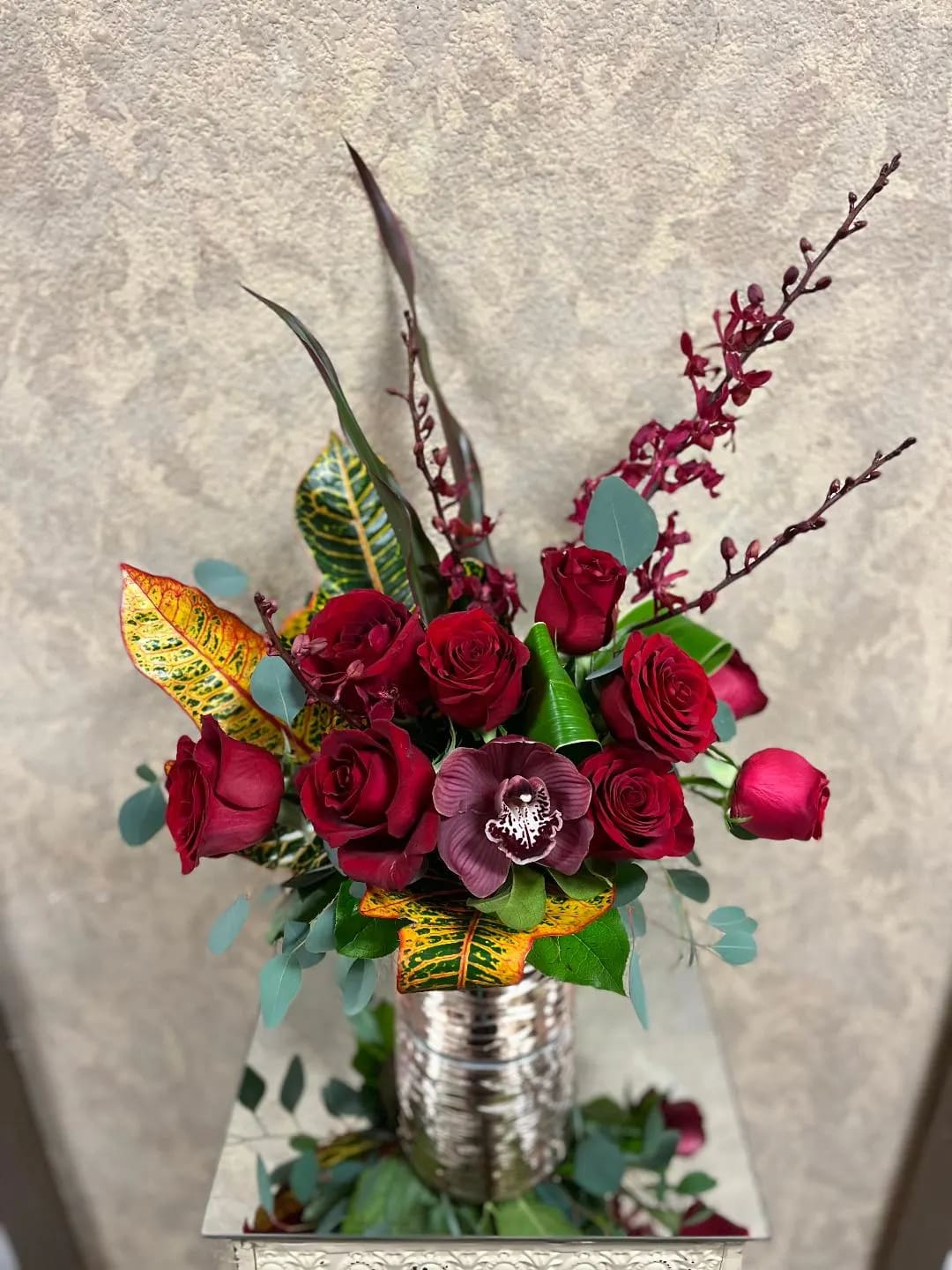 Cupid's Potion - Type of Flowers: Red Roses, Cymbidium Orchids, and Phaleophesis Orchids in a short vase. Availability: All year round Substitute Available: Yes Design View: Symmetric Front Facing View Photo shown: Regular 