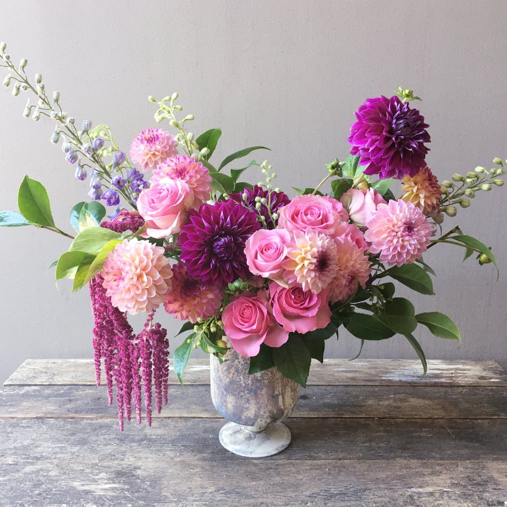 Aria (Gallery Photo) - An artful expression of a floral creation! Gorgeous blooms of dahlias and roses with gracefully hanging amaranth in pinks tones will bring beauty to anyone’s day!
