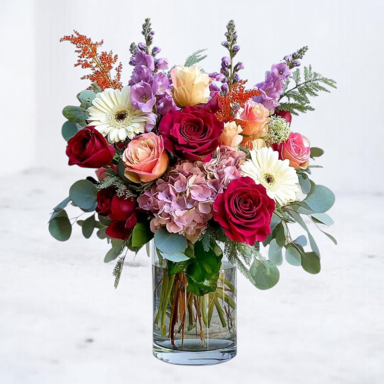 Floral Serenade Bouquet Floral Serenade Bouquet - The Floral Serenade Bouquet is a lush, colorful arrangement that celebrates life’s happiest moments. Featuring radiant red roses, peach spray roses, lavender stock, hydrangea, cheerful white gerbera daisies, and warm autumn accents, this design is overflowing with charm. Arranged in a clear glass vase with fresh greenery, it’s the perfect gift for birthdays, anniversaries, or sending a “just because” surprise. Available for same-day flower delivery in Houston and surrounding areas, this vibrant bouquet brings garden-inspired beauty straight to their door.