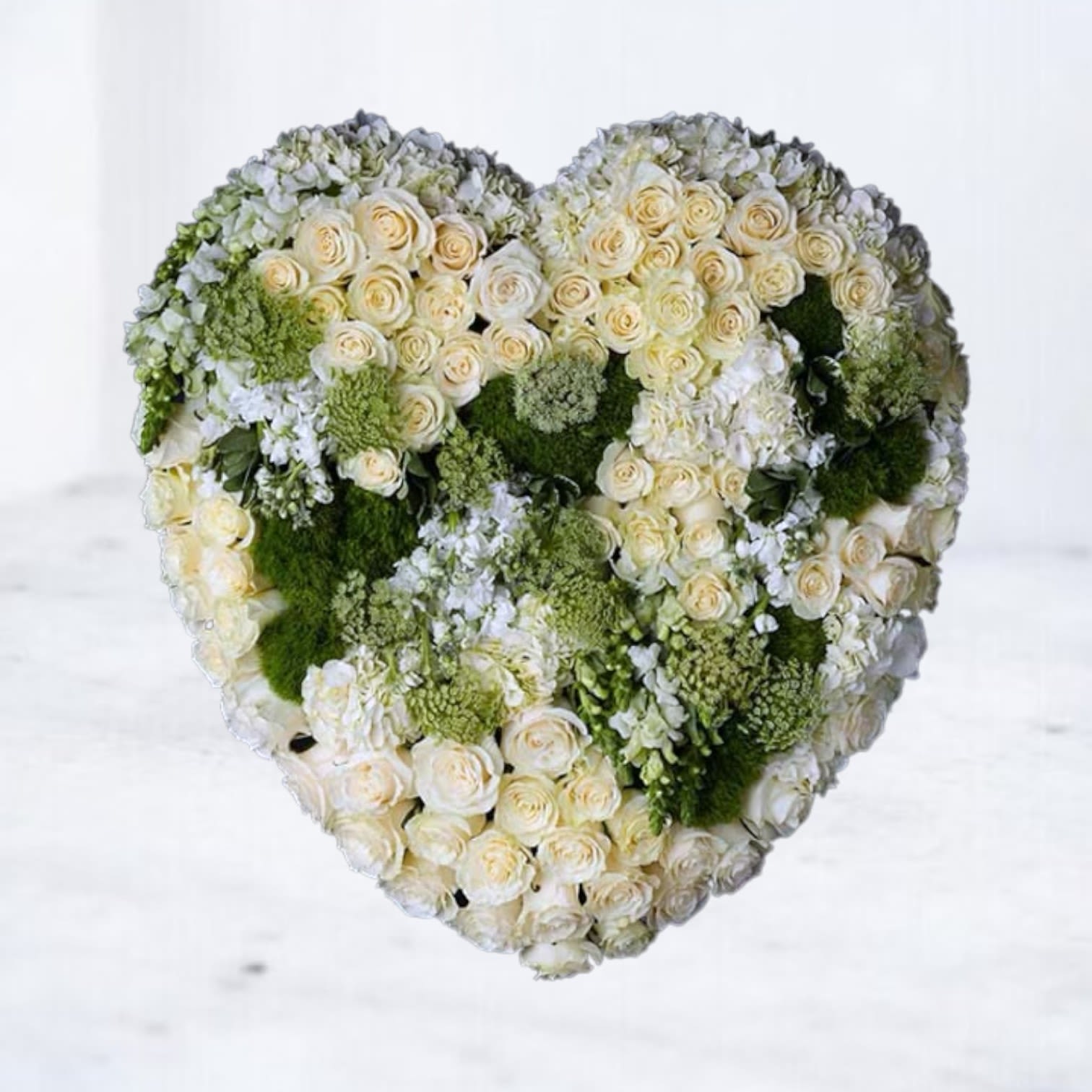 Tender Remembrance Heart Tender Remembrance Heart - The Tender Remembrance Heart is a stunning sympathy tribute, crafted with ivory roses, hydrangea, and lush green textures that symbolize peace, renewal, and eternal love. Its heart-shaped design is a powerful expression of compassion and remembrance, offering comfort to grieving families. This funeral heart makes a beautiful statement at funeral services, memorials, or graveside ceremonies, serving as a heartfelt reminder of everlasting devotion. Available for same-day delivery to funeral homes, memorial services, and residences in Magnolia, The Woodlands, Spring, and Montgomery, TX.