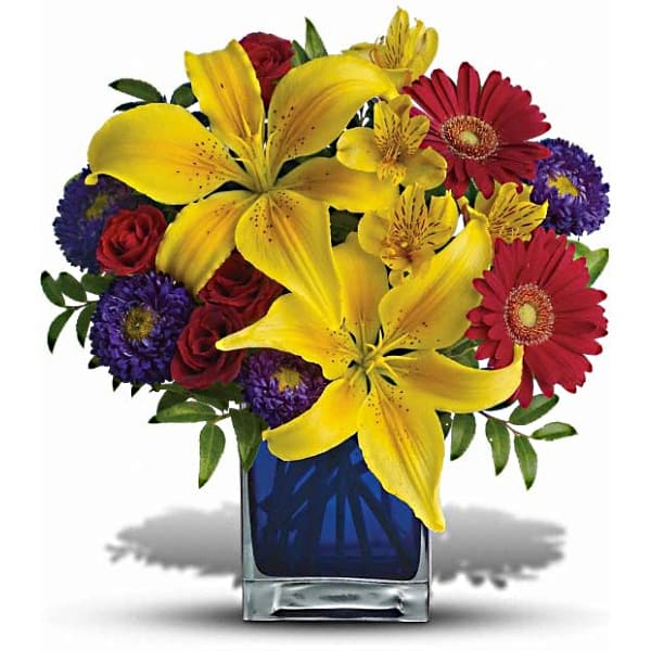 Blue Caribbean   - Martinique, St. Maarten, any tropical paradise is the perfect setting for this explosively colorful bouquet in a chic blue contemporary cube vase. Can't go just now? Bring the island home. 