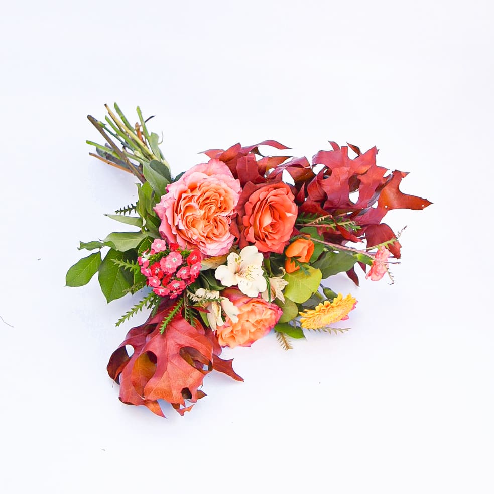 Autumn Embers - Bright orange tones pop in a nest of burgundy and rust. This style evokes the warmth of a blazing bonfire on a crisp fall night.  PLEASE NOTE: Standard price-point is a hand-tied bouquet with no vase. Approximately 12&quot; across the top of the flowers  Deluxe price-point is a low and lush arrangement presented in a short glass cylinder. Approximately 18&quot;W x 14&quot;H  Premium price-point is a high and tall arrangement in a tall cylinder. Approximately 24&quot;W x 28&quot;H.