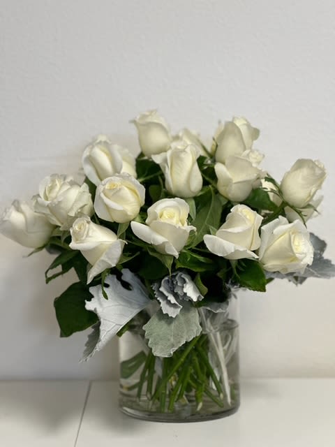 Two Dozen White Roses by Grohe Florists Two Dozen White Roses by Grohe Florists - Make a bold statement with this elegantly simple design. White roses symbolize hope, honor, adoration, and innocence. Two Dozen White Roses by BloomNation⢠is the perfect gift to welcome new beginnings or show your respects. Arrangement Details: Three dozen red roses in a glass cylinder vase. APPROXIMATE DIMENSIONS are 11"D X 12"H