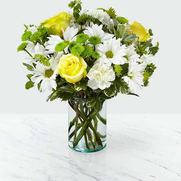 Happy Day Bouquet - It's amazing the effect flowers can have on its recipient. Through a collection of yellow roses and luminous bupleurum all set within a recycled cylindrical glass vase, our Happy Day bouquet is sure to bring a smile to the face of whoever it's given to. Add the combination of white daisy pompon and green button pompon, and you’ll be making their day brighter with each sunny petal.  Details 14&quot;h x 14&quot;w  Bloom Details Rose Carnation Daisy