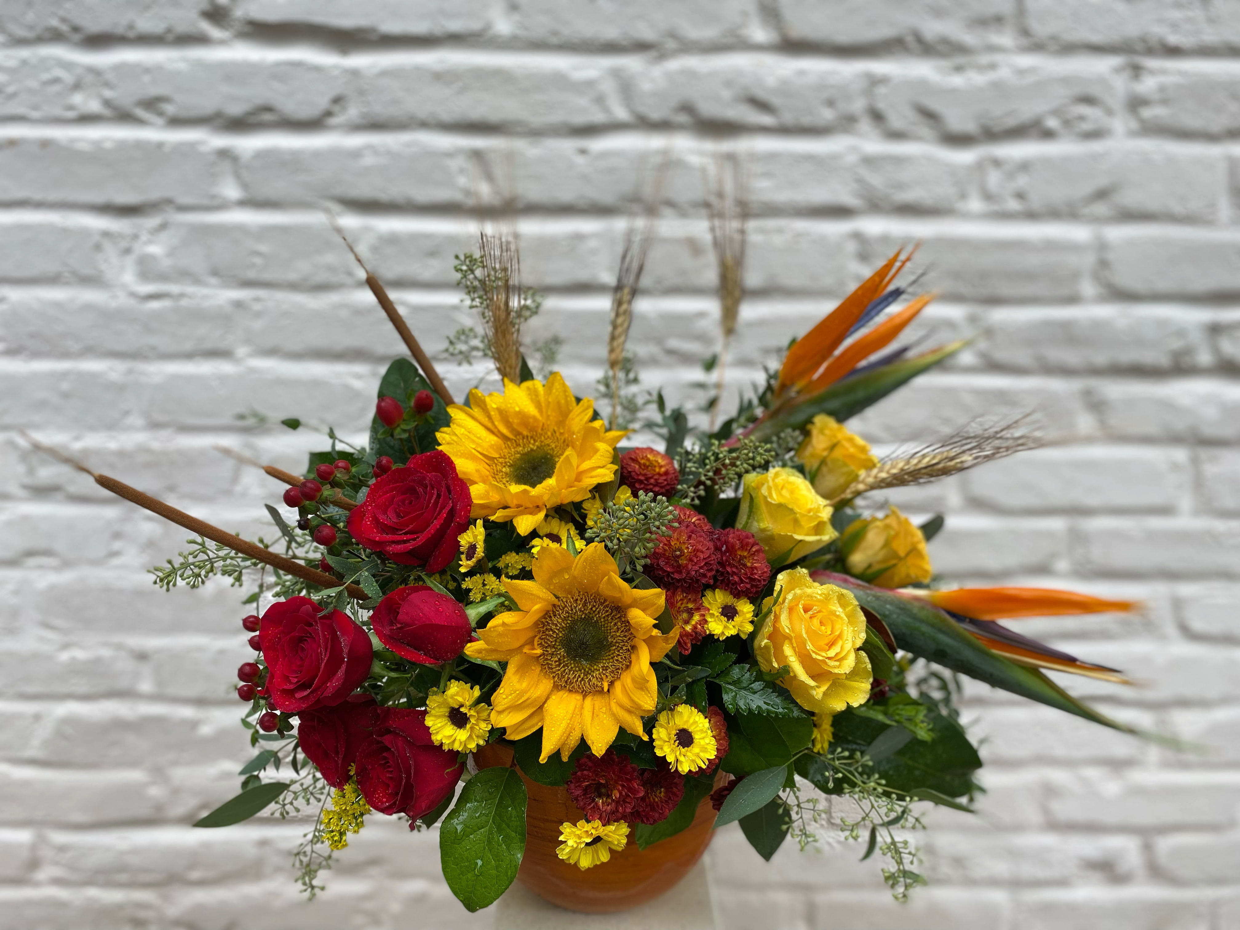 Fall Lovin' Fall Lovin' - Send good someone's way with this striking arrangement. Roses, sunflowers, and beautiful birds of paradise.