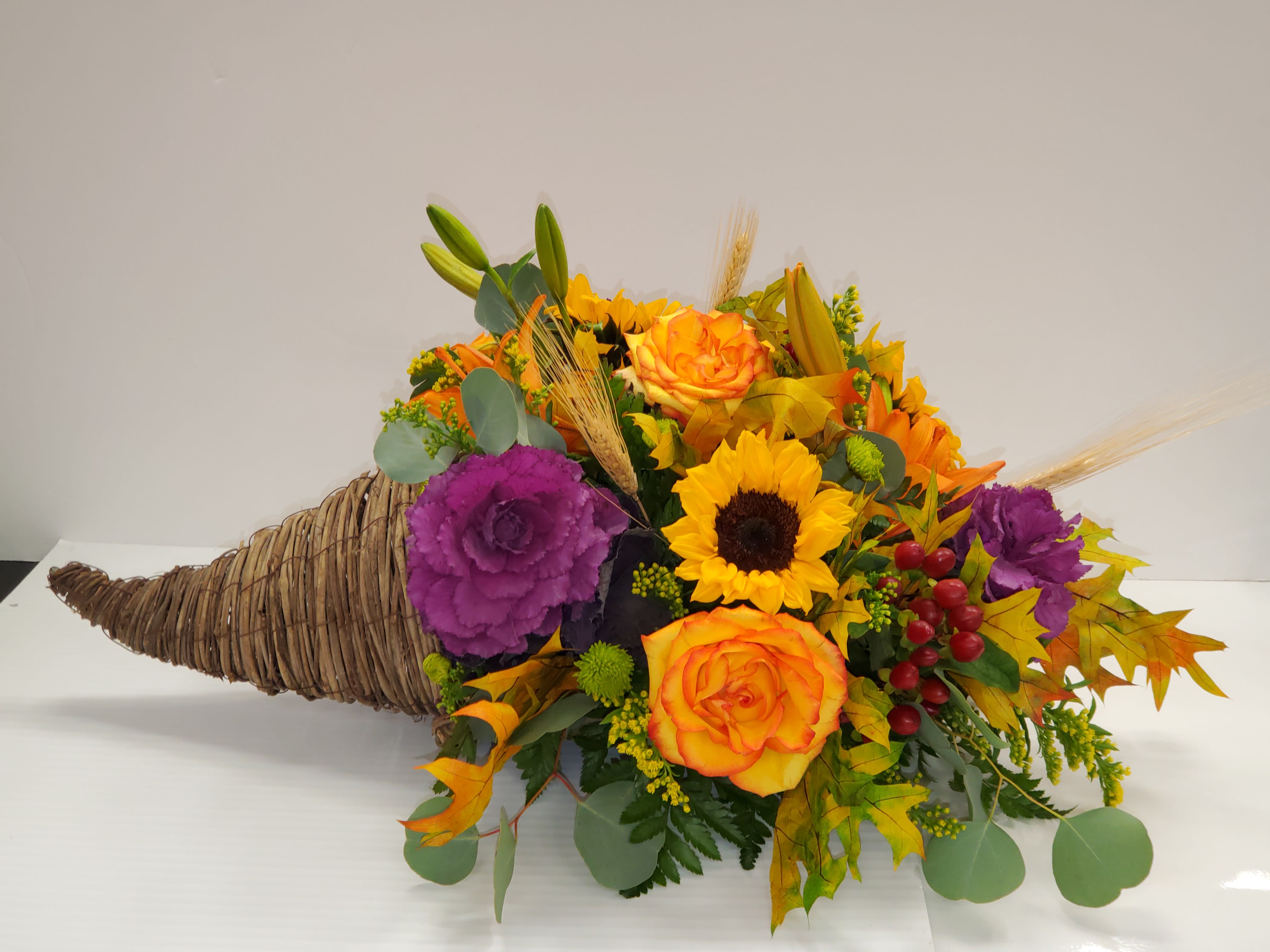 Fall Cornucopia - 4 orange roses, 3 sunflowers, 2 orange lilies, 3 green atus, 3 solidagos, 3 berries,3 purple kales, fall leaf and silver dollar. 