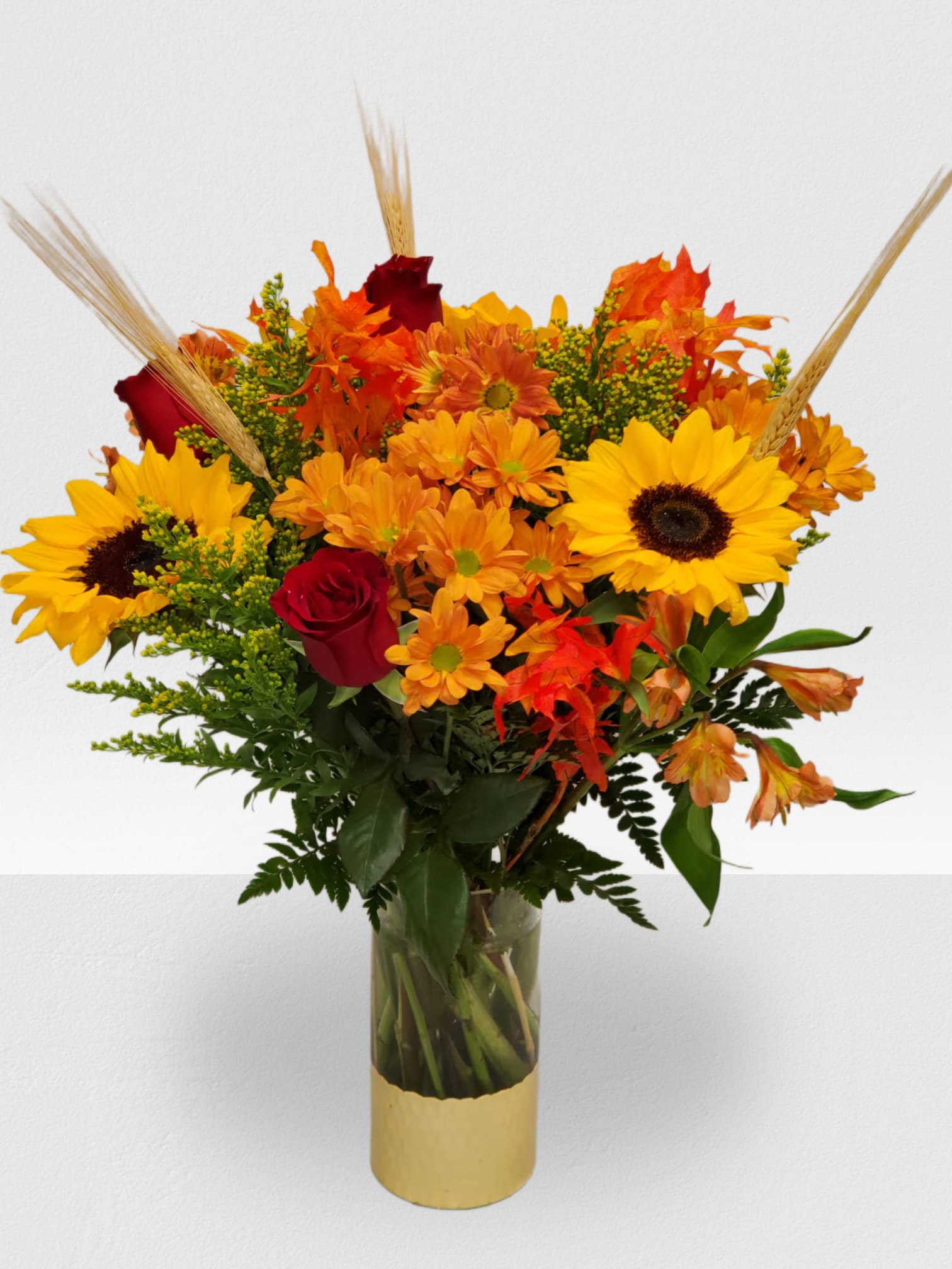 Fall In Love - Clear with gold vase, 3 sunflowers, 4 fall daysis, 3 orange astro, 4 yellow solidago, 3 wheats, 4 red roses, fall leafs
