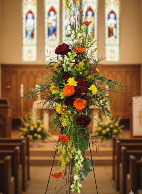 Cross Funeral Flowers - Compassion, faith, and hope are what we wish to bring you during this challenging time in your life. Our designers have crafted this special selection of peace-giving for the family to celebrate their loved ones.  These sympathy flowers are bright in color for hope, with red roses, orange gerbera daisies, and white snapdragons.  We design with birch sticks to form the cross and the flowers cascading down into the cross.  If you are looking to have Sympathy Flowers delivered in Olympia, Wa, we can definitely do that for you.  We are a local family-owned florist located in Olympia, Wa area but will deliver to Tumwater and Lacey areas too.  Our team is here to help with the family's needs during a difficult time.  Please call us here at Specialty Floral Design or order online. 