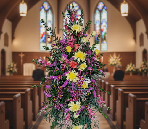 Celebration of Life - Honor a beautiful soul with our Celebration of Life Standing Spray — a bright and uplifting floral tribute created to reflect the love, joy, and unforgettable memories shared. This vibrant spray is designed with an eye-catching mix of pinks, oranges, yellows, and purples, symbolizing warmth, happiness, and a life well-celebrated. It's a heartfelt expression of sympathy and a beautiful way to bring comfort and light to those gathered.  Sympathy flowers have long played an important role in offering support during times of grief. They serve as a visual reminder of the love and community surrounding those in mourning and can bring peace and healing simply through their natural beauty. A standing spray like this one makes a bold and respectful statement, standing tall and proud near the casket or at the front of the service.  At Specialty Floral Design, we understand how meaningful it is to honor a loved one with flowers that reflect their personality and the life they lived. As your local florist in Olympia, WA, we handcraft every sympathy arrangement with care and attention to detail.  We offer delivery to all local funeral homes, including: - Woodlawn Funeral Home - Alternatives Funeral &amp; Cremation Services - Mills &amp; Mills Funeral Home  We also serve the surrounding areas, including Tumwater and Lacey, WA.  Let us help you share your compassion and memories through a floral arrangement designed to celebrate life and love.      