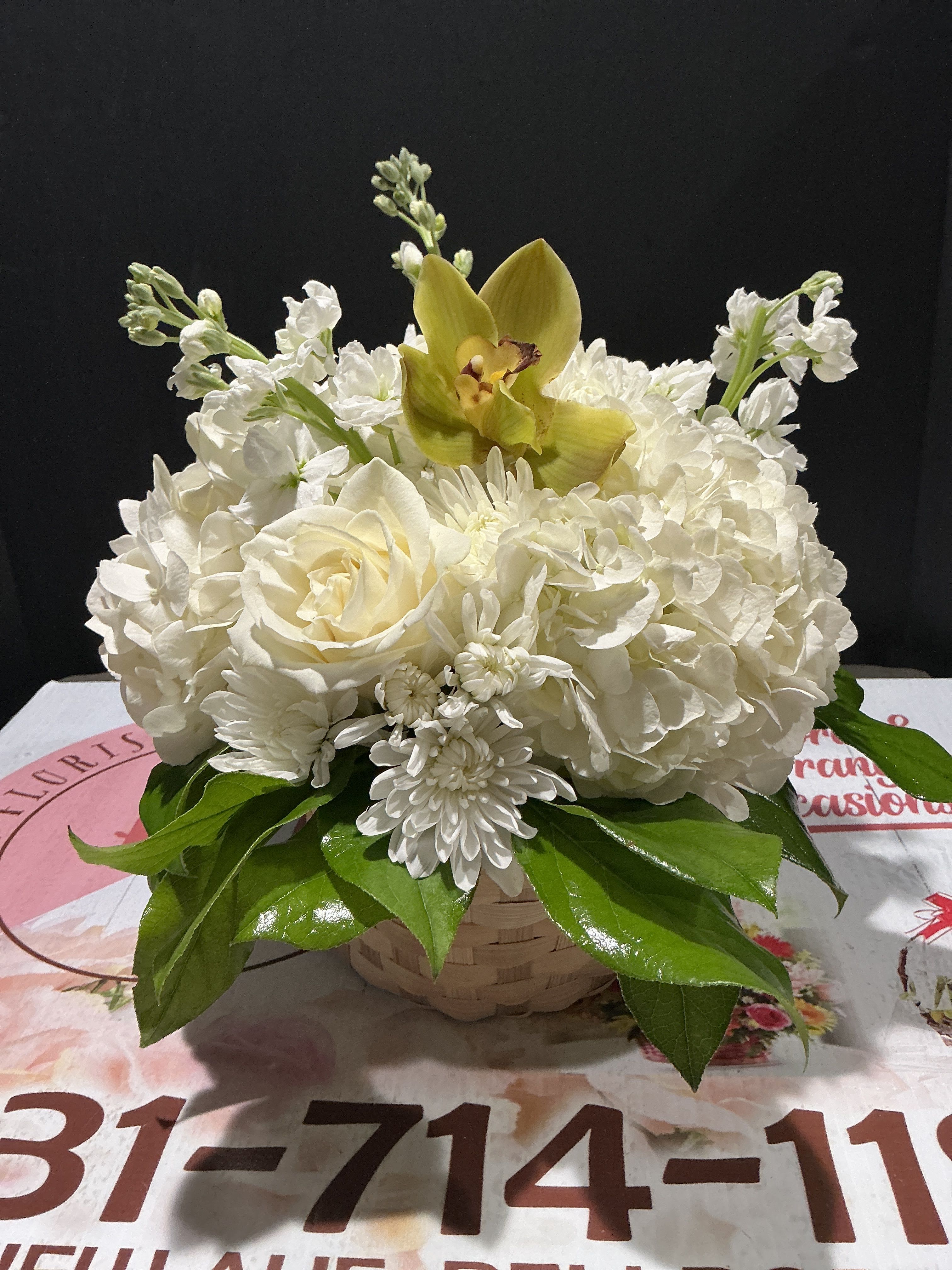 Remembrance  - Send this all-white arrangement to the family's home to let them know you are thinking of them in their time of loss. Featuring white hydrangea, and white orchids this pure white arrangement is a classic sympathy arrangement.  Diameter 11H 11W. 3 hydragea, (white) 4roses (white) 3 stock (white) 1 orchid, shallow basket