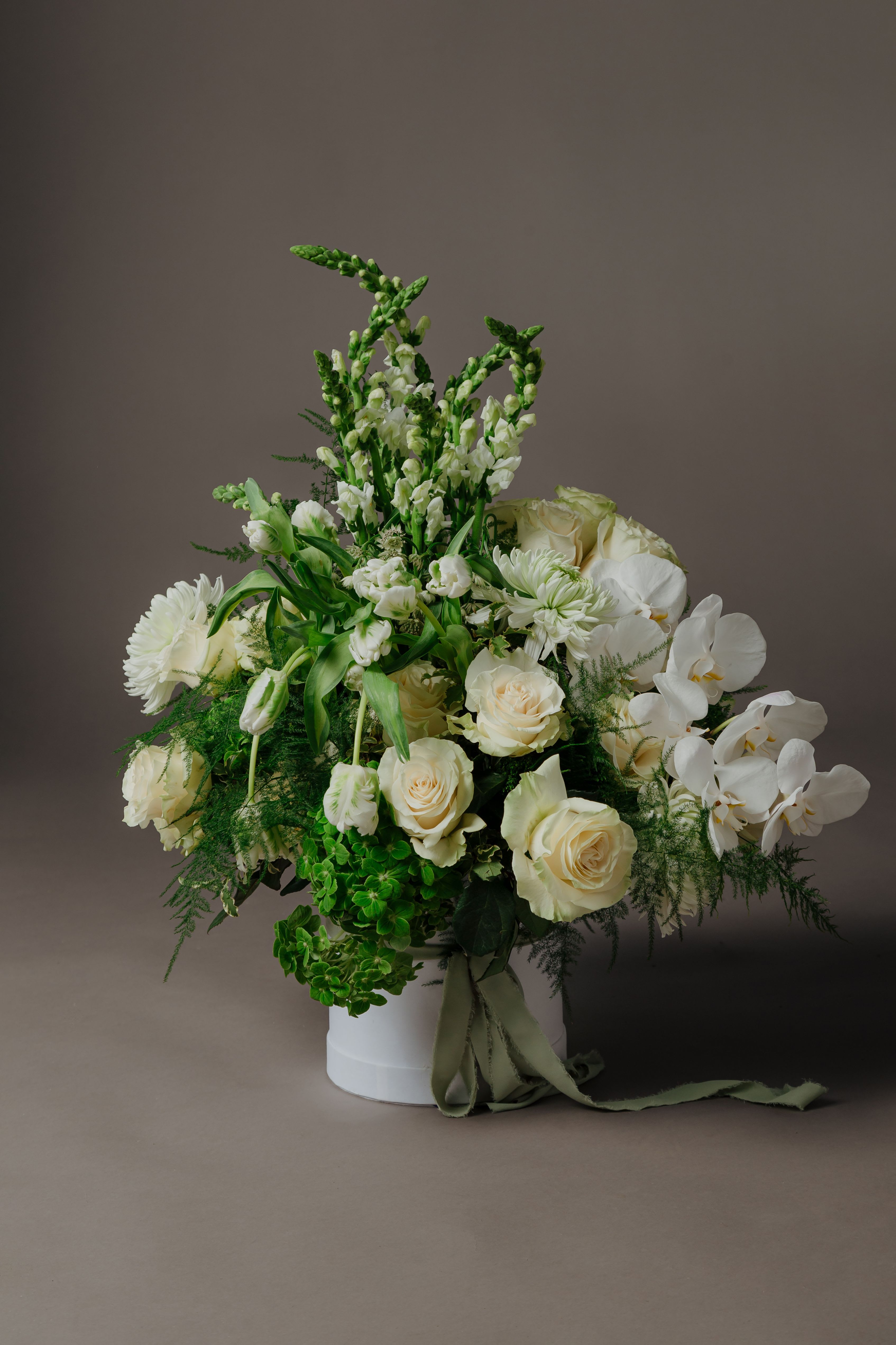Aesthetic White and Green Flower Arrangement – Elegant and Serene Floral Design Aesthetic White and Green Flower Arrangement – Elegant and Serene Floral Design - Presenting the "Aesthetic White and Green Flowers Arrangement for Mom" from Flora by Cortez—an exquisite tribute to the woman who fills our lives with love and grace. Crafted with care and attention to detail, this arrangement features a harmonious blend of pristine white blooms and lush greenery. Symbolizing purity, serenity, and renewal, the white flowers convey heartfelt sentiments of love and gratitude, while the verdant greens add a touch of freshness and vitality. Presented in a chic vase or container, this arrangement exudes understated elegance and sophistication, making it the perfect gift for Mom on her special day. Whether displayed as a centerpiece on the dining table or adorning her favorite space, this arrangement is sure to bring joy and beauty into her life. Show Mom just how much she means to you with our "Aesthetic White and Green Flowers Arrangement." Let its timeless beauty and graceful charm be a lasting tribute to the bond you share.