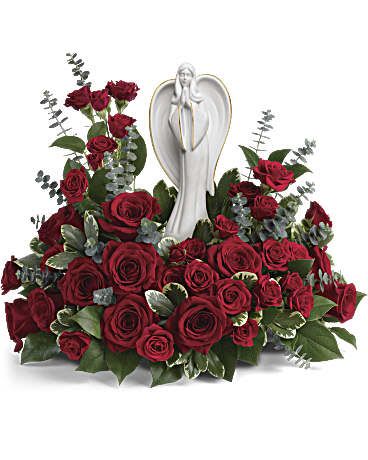 Ivory Elegance - This breathtaking arrangement features a sea of rich red roses, symbolizing deep love and reverence, paired with lush greenery and elegant silver-dollar eucalyptus for a soft, textured contrast. At the heart of the arrangement stands a serene angel figurine, embodying peace and spiritual grace. This design creates a meaningful tribute, perfect for conveying heartfelt condolences, honoring a loved one’s memory, or bringing comfort during a time of loss. The timeless beauty and symbolic elements make this arrangement both elegant and deeply sentimental.