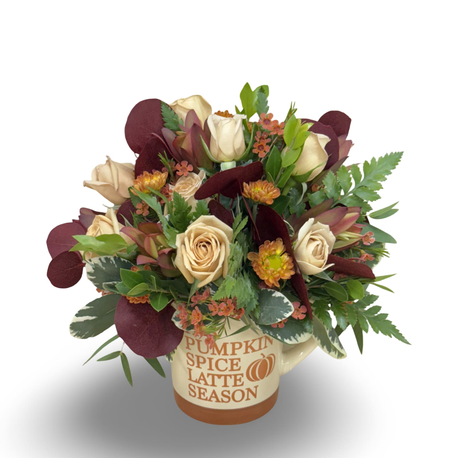 Latte Season - Celebrate cozy autumn vibes with this charming arrangement in a seasonal mug featuring either “Pumpkin Spice Latte Season” or “Pumpkin Spice and Everything Nice.” Filled with tan spray roses, orange wax flowers, warm-toned pom poms, safari, and tinted eucalyptus, it measures approximately 8.5” x 5” and is perfect for brightening a desk, kitchen, or cozy corner.