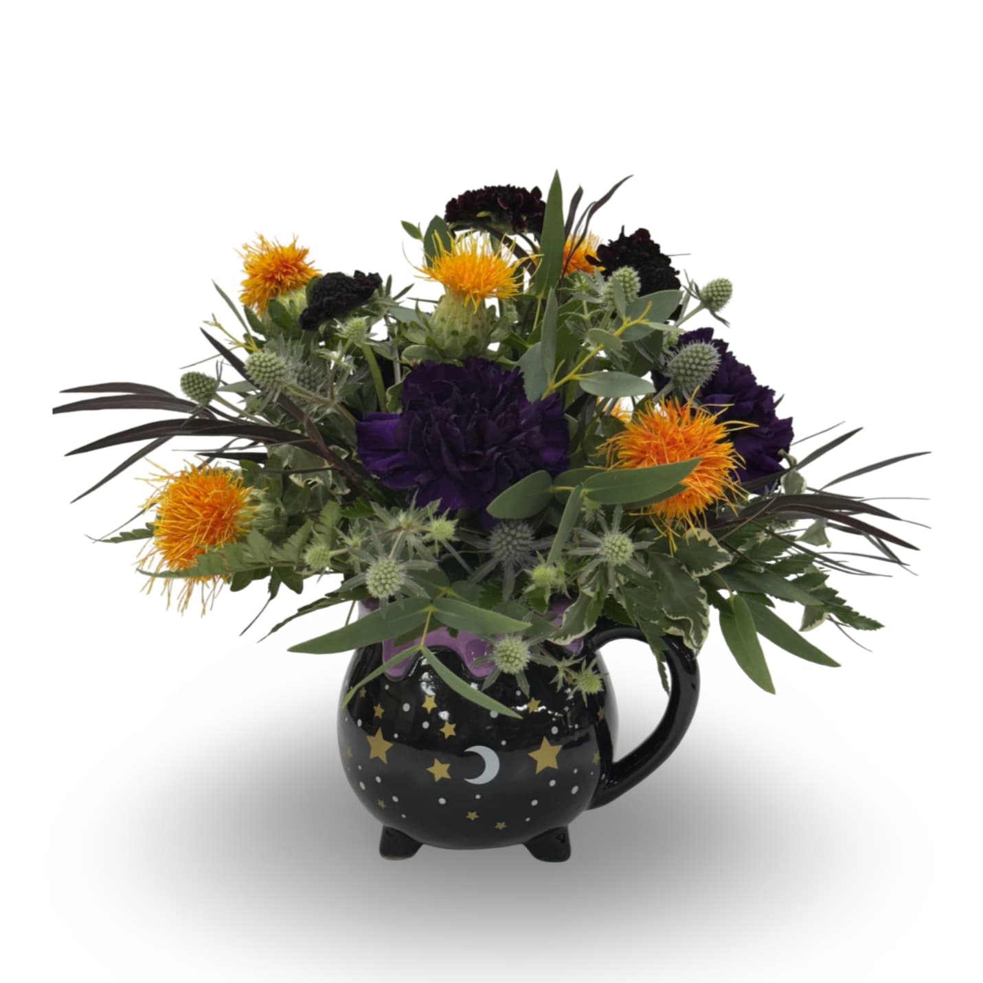 Witch's Brew Witch's Brew - Add a touch of magic with this enchanting arrangement in a cauldron-style mug decorated with stars and moons. It features orange safflower, deep purple carnations, eryngium, and scabiosa. Approximately 10” x 12”, it can be admired from all angles.