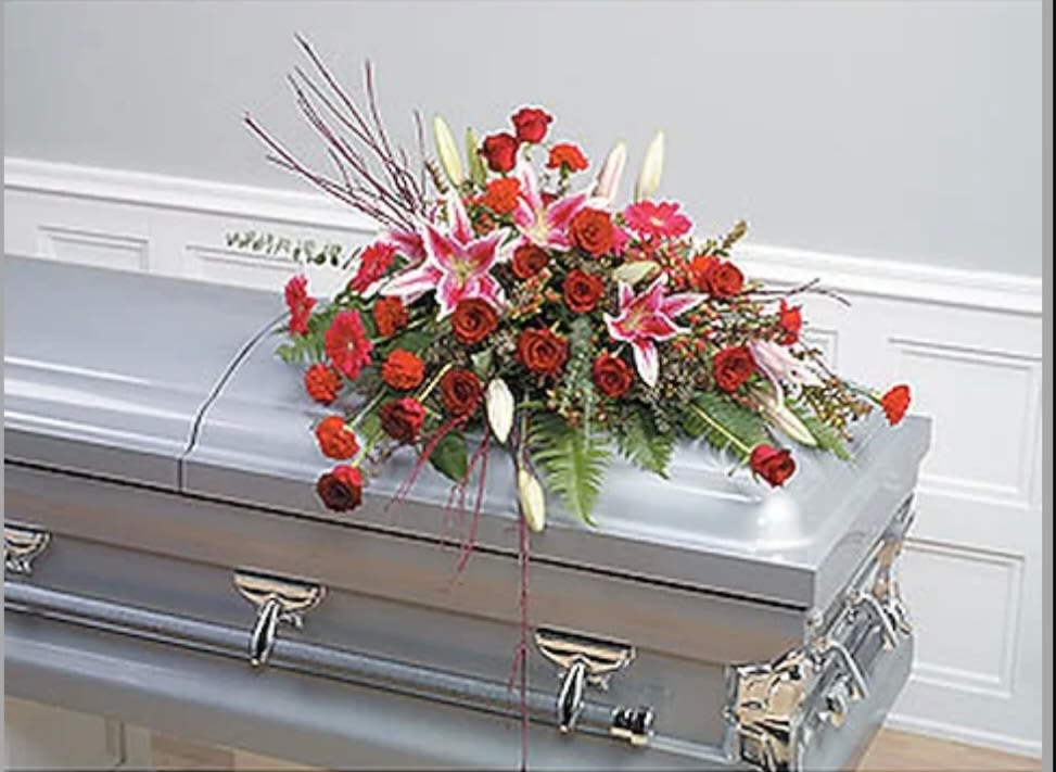Loving Tribute Loving Tribute - This casket spray features red roses, lilys, carnations and gerbers. Such a stunning piece for your family.
