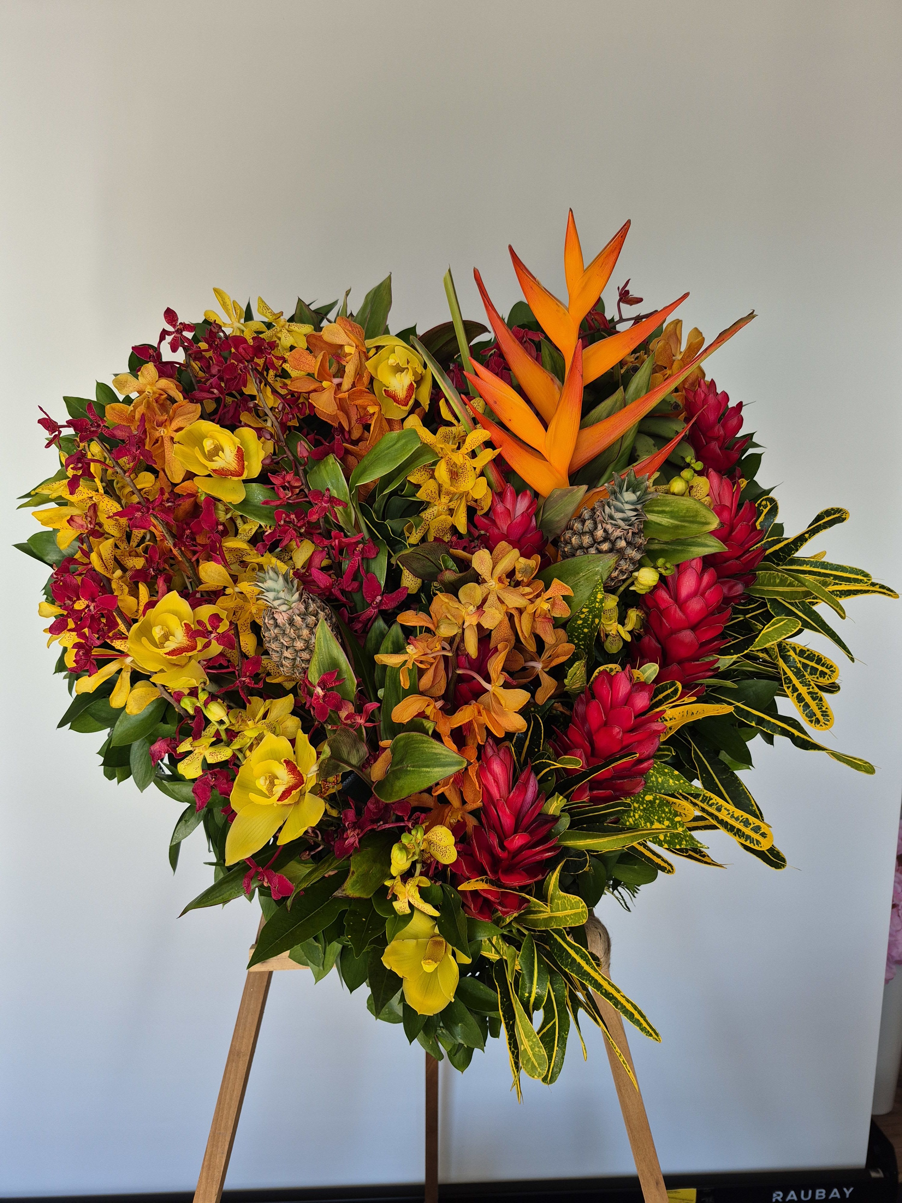 Aloha Paradise Heart Wreath - The stunning vibrant stand immerses you in a peaceful atmosphere, promoting relaxation, and calmness. Made with Aloha the highest quality fresh tropical flowers.   Standard Size 18x18 Deluxe Size 20x20 Premium Size 24x24 