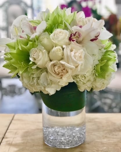 Mable Mable - Mixed floral arrangement with soft white color hue of white roses, spray rose hydrangeas with pop element of green lilies and green monstera leaf gracefully sweeps around glass cylinder vase Some florals are seasonal, if particular flower will not be available due to season, we will substitute for similar flower, composition, color pallet and value of the arrangements as closely as possible. All effort to create a floral arrangement as close to the photo shown, the actual arrangement may vary slightly in its appearance from the photo shown. If you have any questions about your order, we welcome you to call us in or email