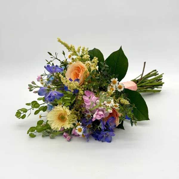 Spring Garden Nosegay - Colorful look with a variety of fresh spring florals that will vary based on availability. When ordering please specify your choice of satin ribbon color under special instructions or it will be wrapped in a corresponding color. Designers may need to implement substitutions, however will follow the general arrangement style and color theme. Standard price point is pictured.