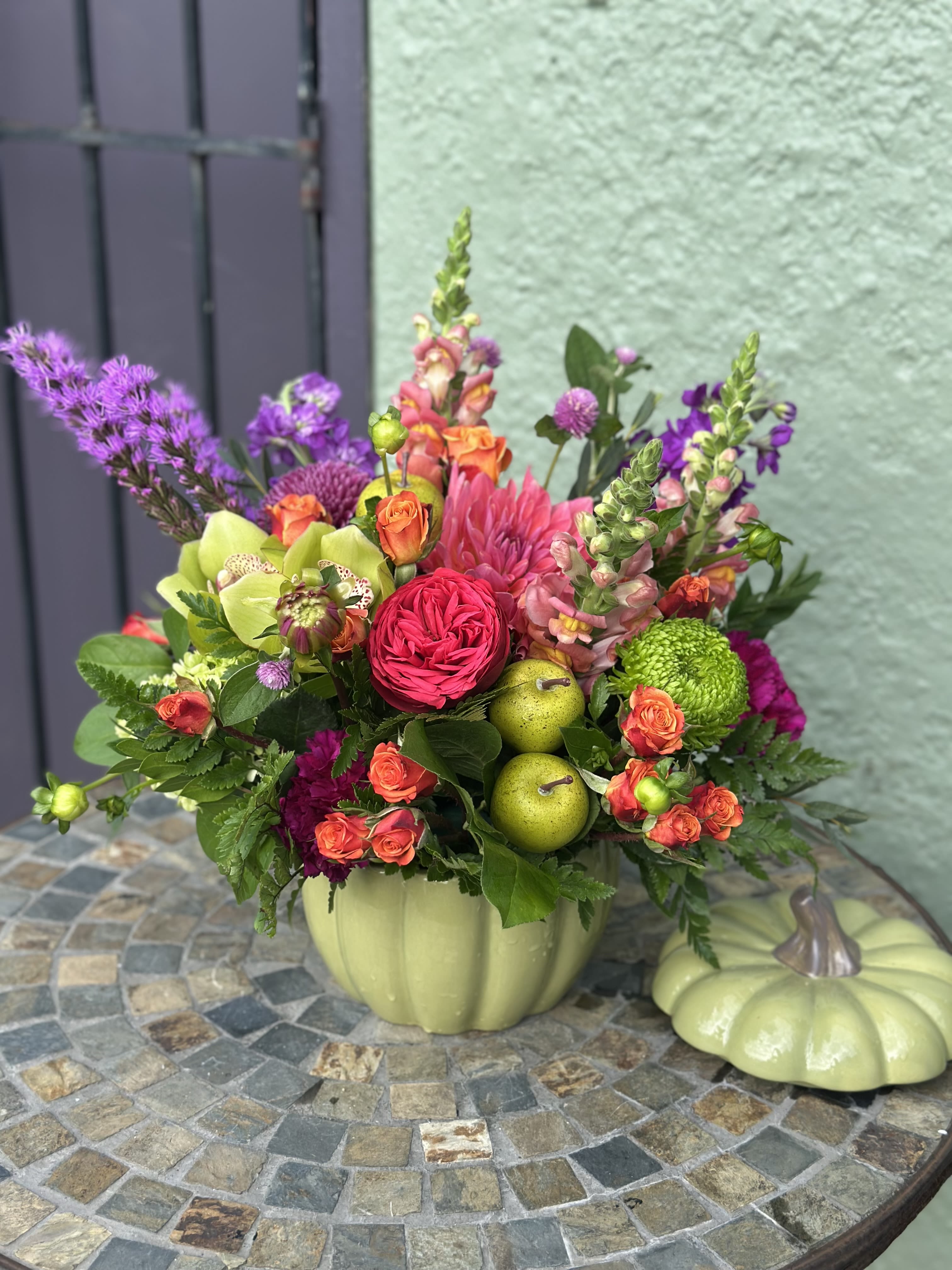 Autumn's Jewel Box - Bold colors and textures come alive in this frestive design, where dahlias, roses, and orchids sparkle like treasures tucked inside a ceramic pumpkin container.