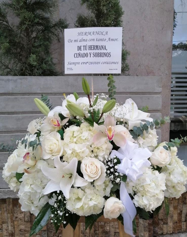 Arreglo floral con condolencias - Hermoso arreglo funebre en tonos blancos, elaborado con lirios, hortensias, orquideas y follaje verde.