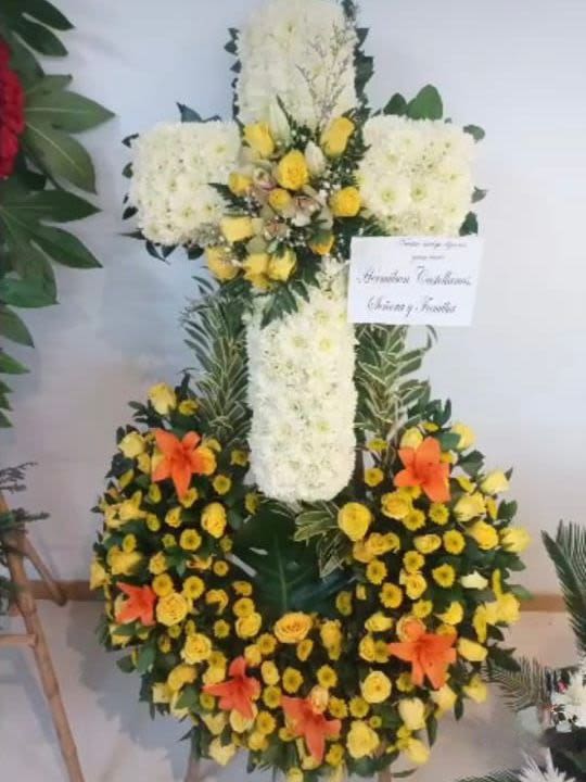 Cruz de eterno descanso - Arreglo funebre en forma de cruz elaborado con flores blancas, lirios naranjas .